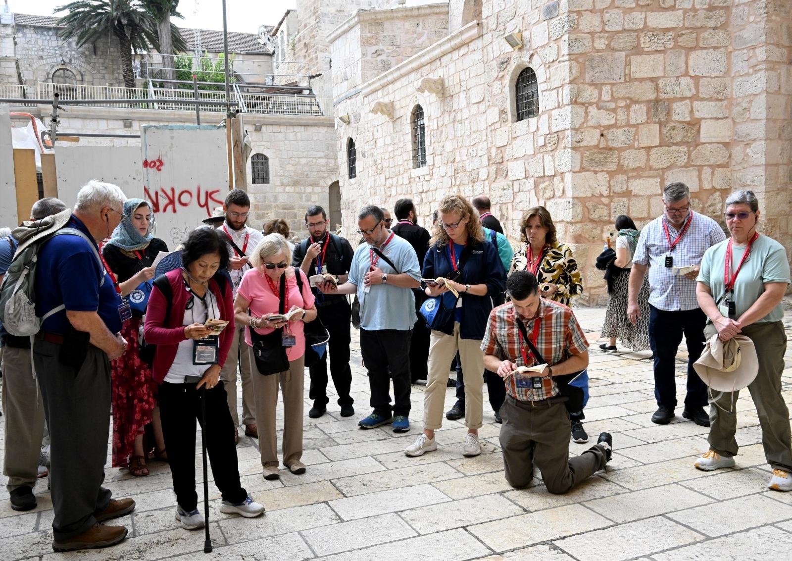 Pilgrims from the Diocese of Arlington, Va., pray in the courtyard of the Church of the Holy Sepulcher in Jerusalem's Old City Oct. 10, 2023. Pilgrims who were in Israel following a surprise terrorist attack by Hamas against civilian communities in southern Israel Oct. 7 lit candles and said prayers of peace at the church as fighting continued in southern Israel. (OSV News/Debbie Hill)