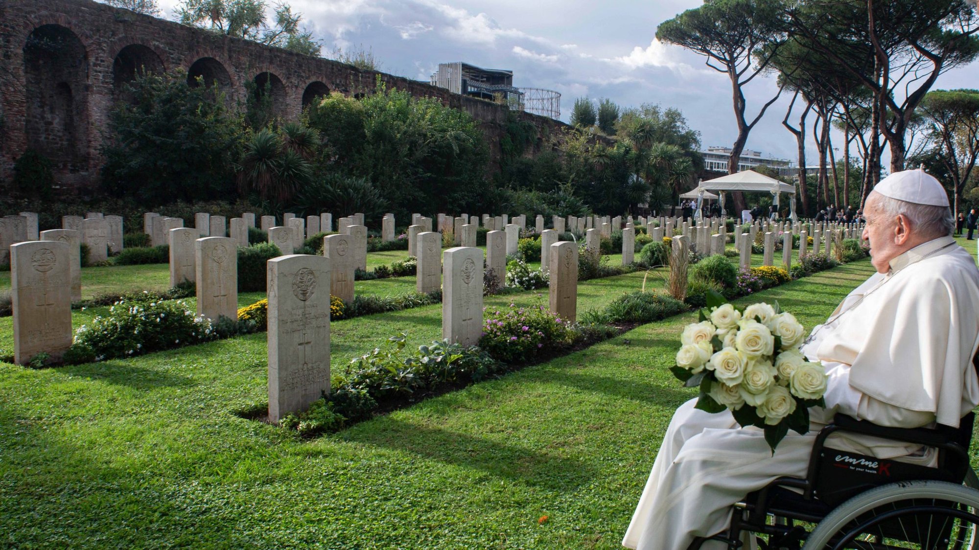 Pope Francis holds a bouquet of white roses as he visits the graves of members of Commonwealth military units who died during and immediately after World War II and now rest in the Rome War Cemetery where the pope celebrated Mass Nov. 2, 2023, the feast of All Souls. (CNS/Vatican Media)