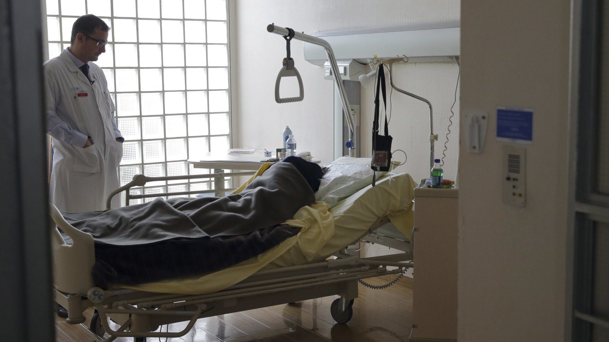 A doctor visits a patient in the palliative care unit of a hospital in Paris March 4, 2015. (CNS photo/Philippe Wojazer, Reuters)