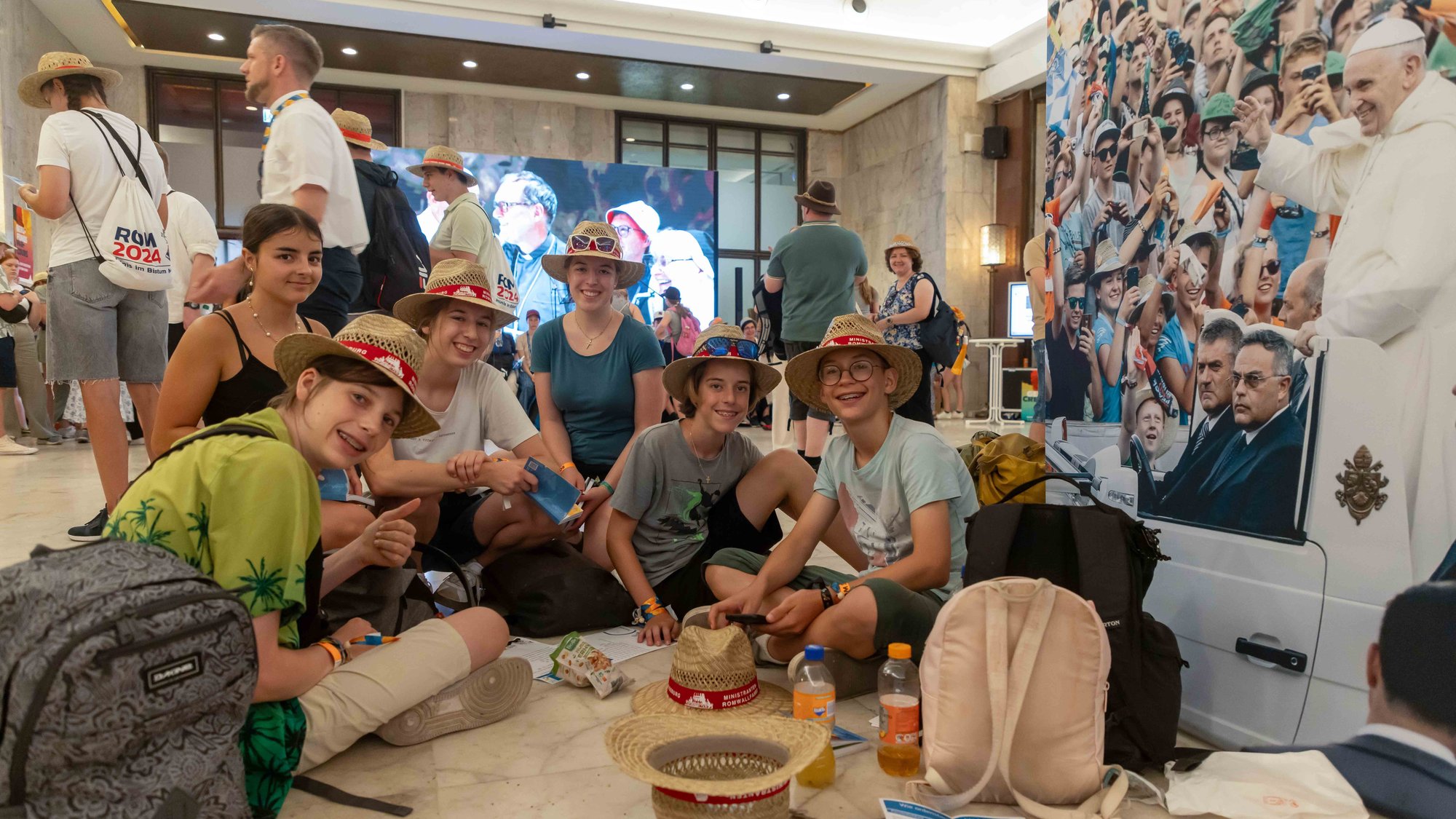A group of young people pose for a photo at a temporary pilgrimage center in a Rome auditorium during the XIII International Pilgrimage of Altar Servers in Rome July 31, 2024. More than 50,000 altar servers from 20 countries went to Rome for the July 29-Aug. 2 pilgrimage. (CNS photo/Pablo Esparza)