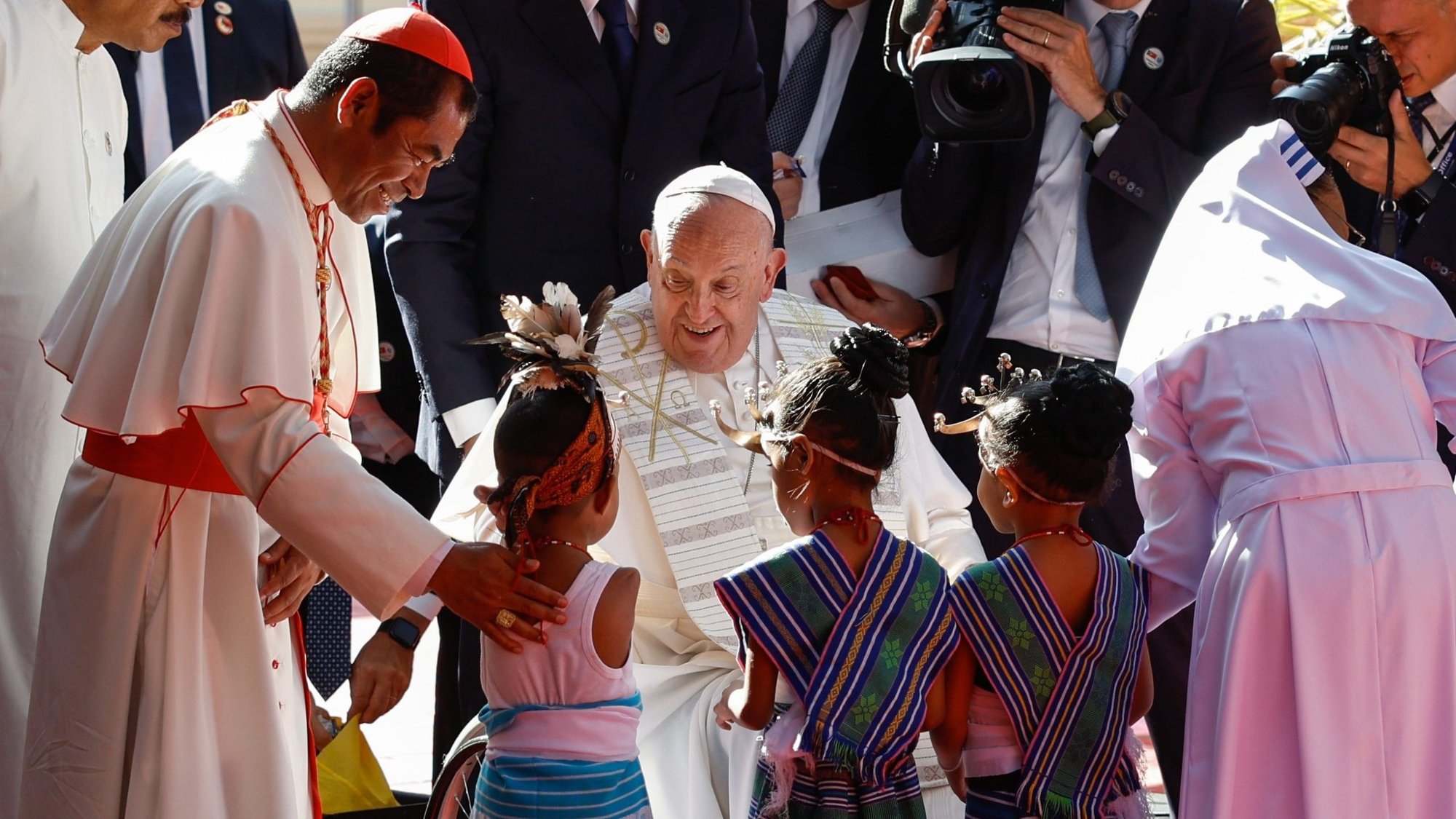 Pope Francis greets children in traditional dress during a visit with children who are seriously ill or have severe disabilities at the Irmas Alma School in Dili, Timor-Leste, Sept. 10, 2024. He is joined by Cardinal Virgílio do Carmo da Silva of Dili.(CNS photo/Lola Gomez)
