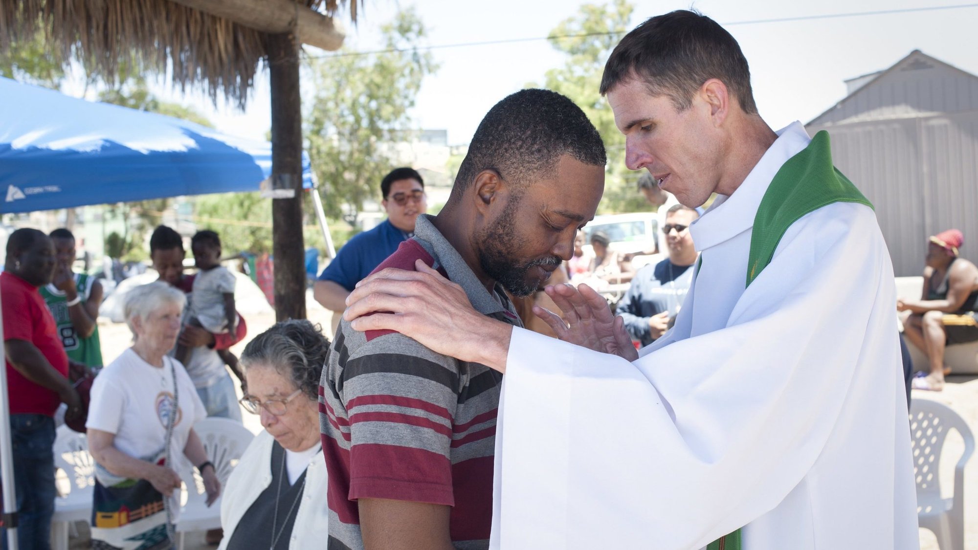 Father Brad Mills, associate pastor at Our Lady of Guadalupe Parish in San Diego, blesses an unidentified man as he celebrates Mass for Haitian migrants at a shelter in Tijuana, Mexico, June 20, 2023. The shelter, which is called Villa Haitiana, is run by Franciscan sisters in Tijuana and houses about 180 people. Many had recently migrated to Mexico from Brazil and Chile. (OSV News photo/David Maung)
