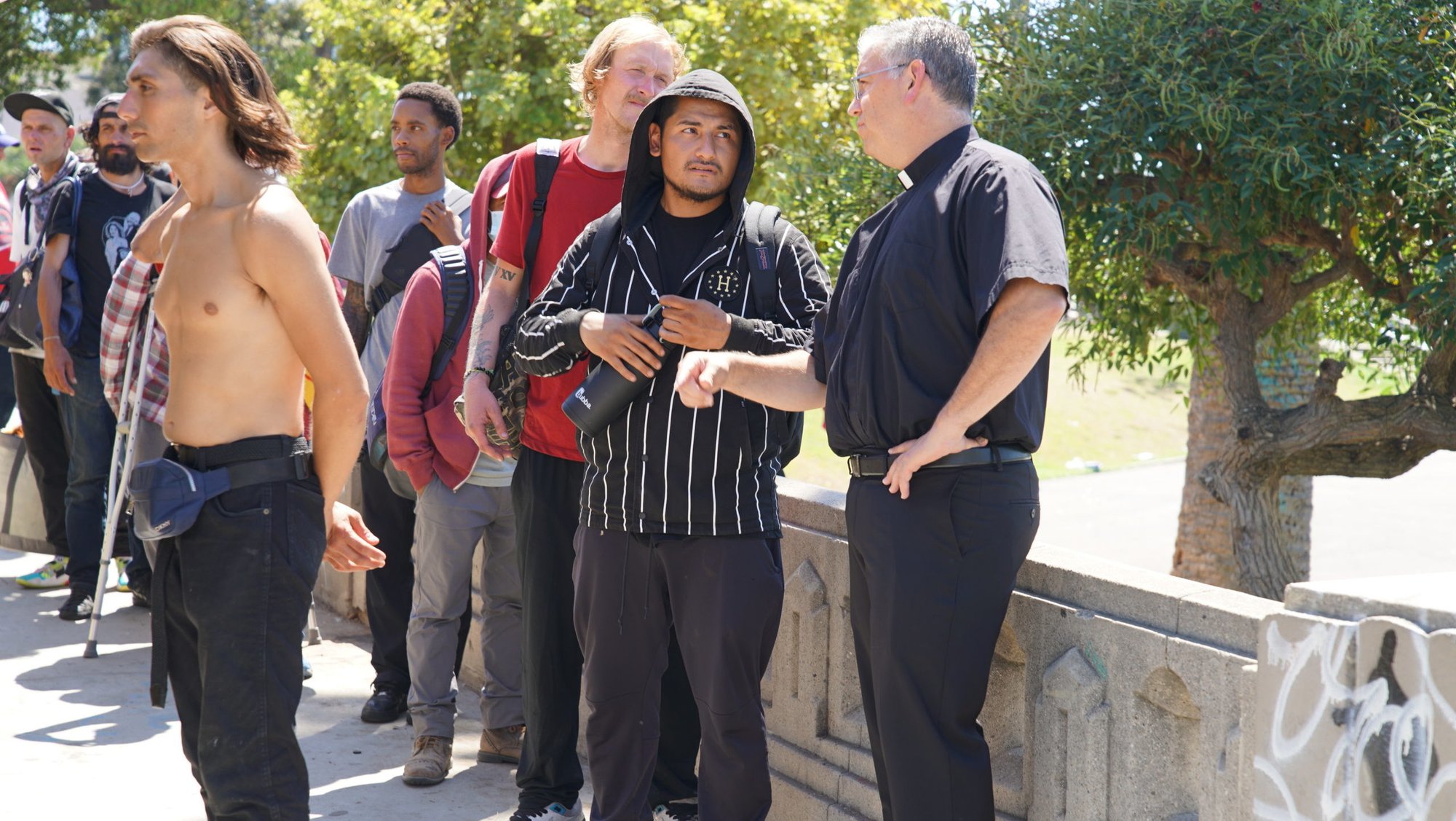 Father Ed Benioff, pastor at Church of the Good Shepherd in Beverly Hills, stands with those standing in line to be fed by the Feed My Poor food truck that brings hot meals to the needy seven days a week. (John Rueda)