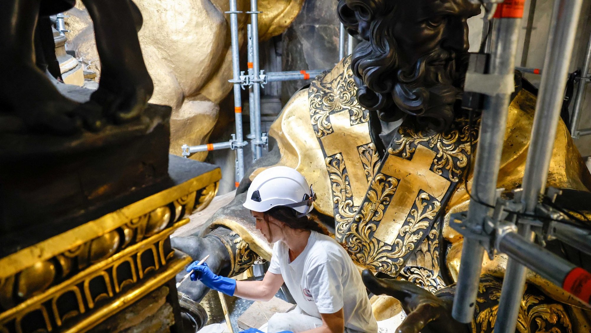 A restoration professional cleans a statue atop the Altar of the Chair in St. Peter’s Basilica during restoration work at the Vatican, Oct. 8, 2024. (CNS photo/Lola Gomez)