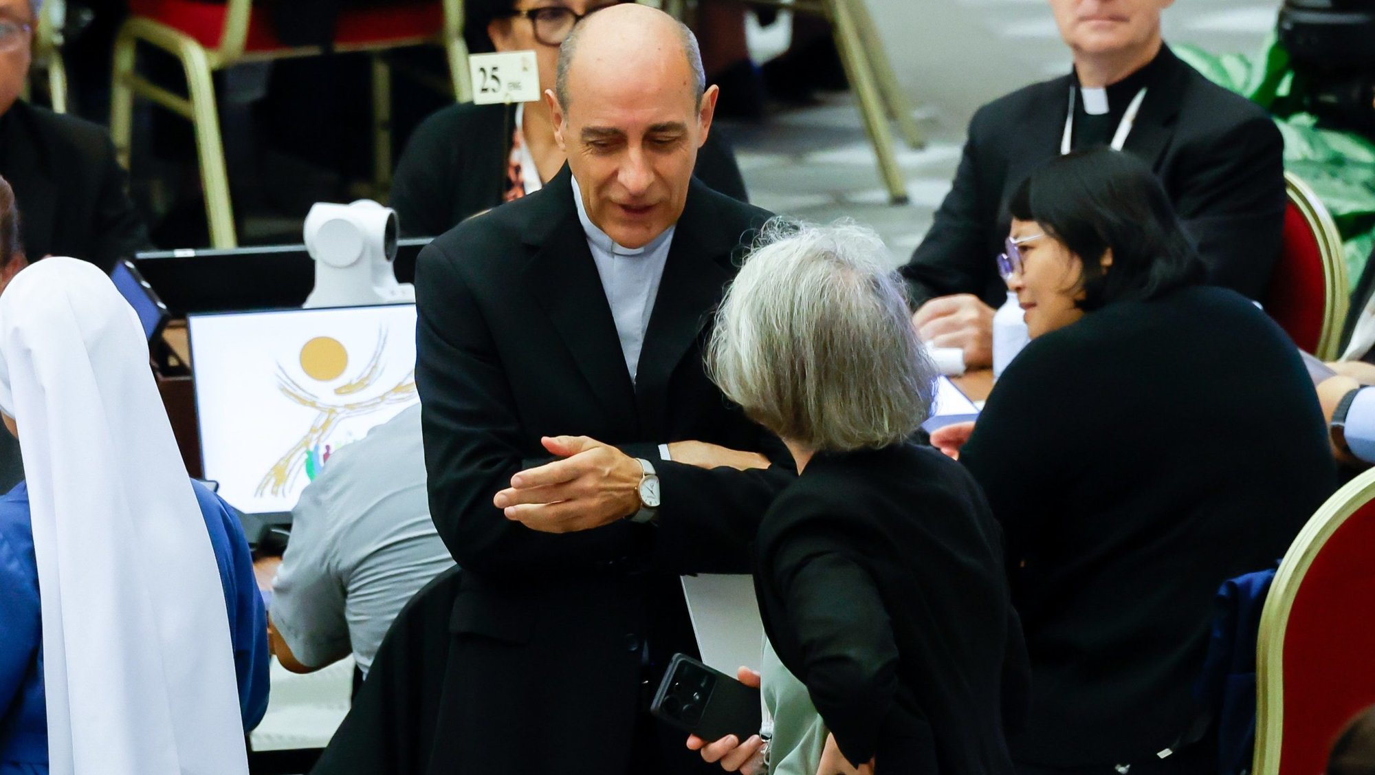 Cardinal Víctor Manuel Fernández, prefect of the Dicastery for the Doctrine of the Faith, speaks with Xavière Missionary Sister Nathalie Becquart, undersecretary of the Synod of Bishops, before the start of a morning session of the synod in the Paul VI Audience Hall at the Vatican Oct. 21, 2024. (CNS photo/Lola Gomez)