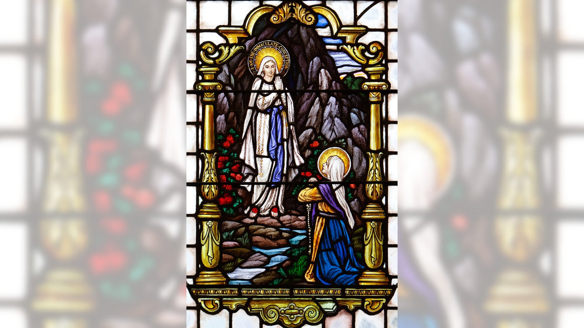 This stained-glass window at St. Mary Church in Manhasset, New York, depicts Mary appearing to St. Bernadette Soubirous in Lourdes, France, as the Immaculate Conception in 1858. (CNS/Gregory A. Shemitz)