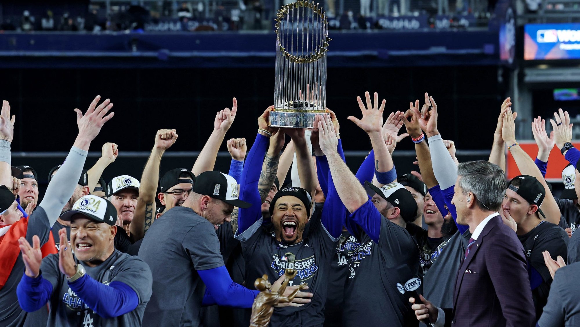 Dodgers right fielder Mookie Betts, center, holds up the Commissioner’s Trophy after beating the New York Yankees to win the 2024 MLB World Series. (OSV News/Brad Penner-Imagn Images)