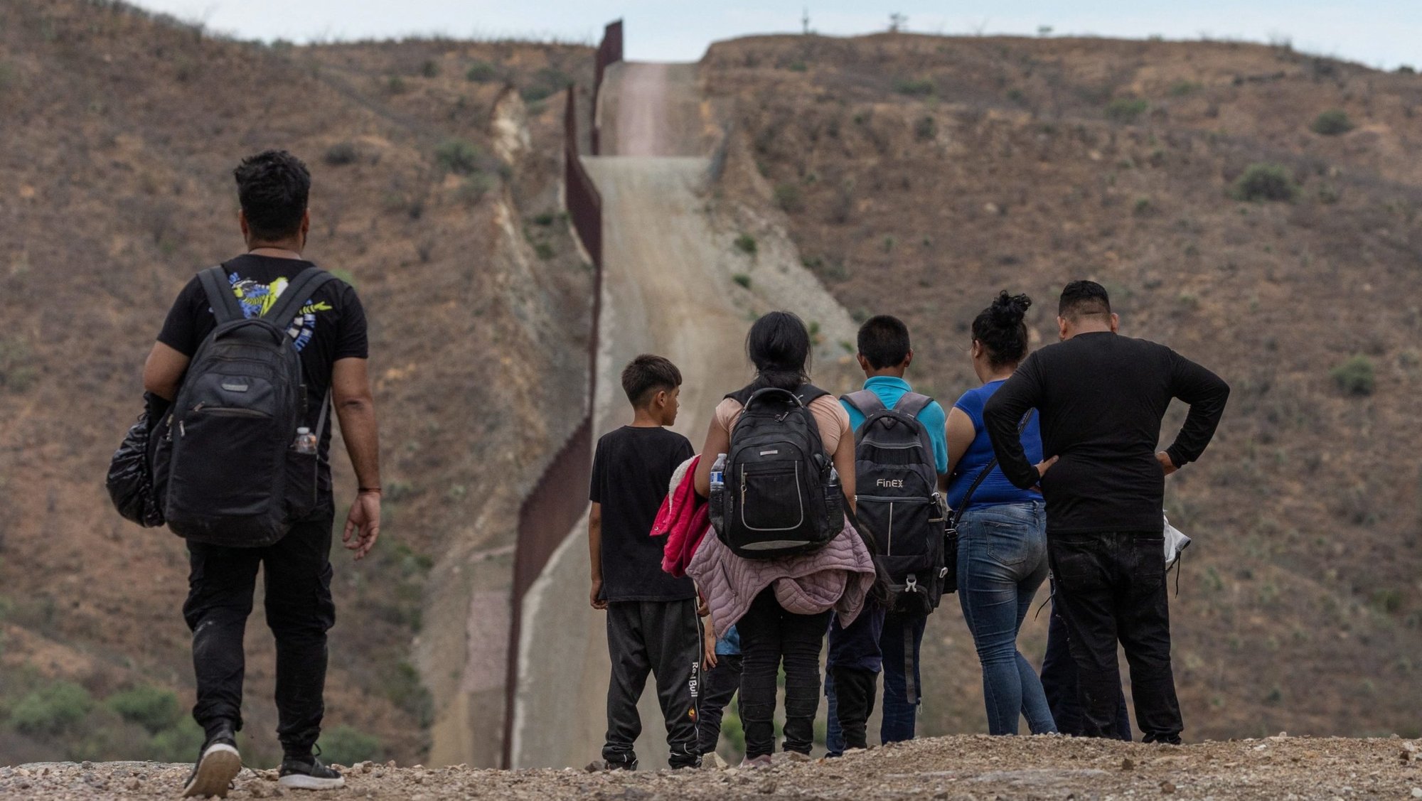 The Border Wall is seen in the background as migrants from South and Central America look to surrender to immigration officials after crossing into the United States from Mexico in Ruby, Arizona, June 24, 2024. (OSV News photo/Adrees Latif, Reuters)