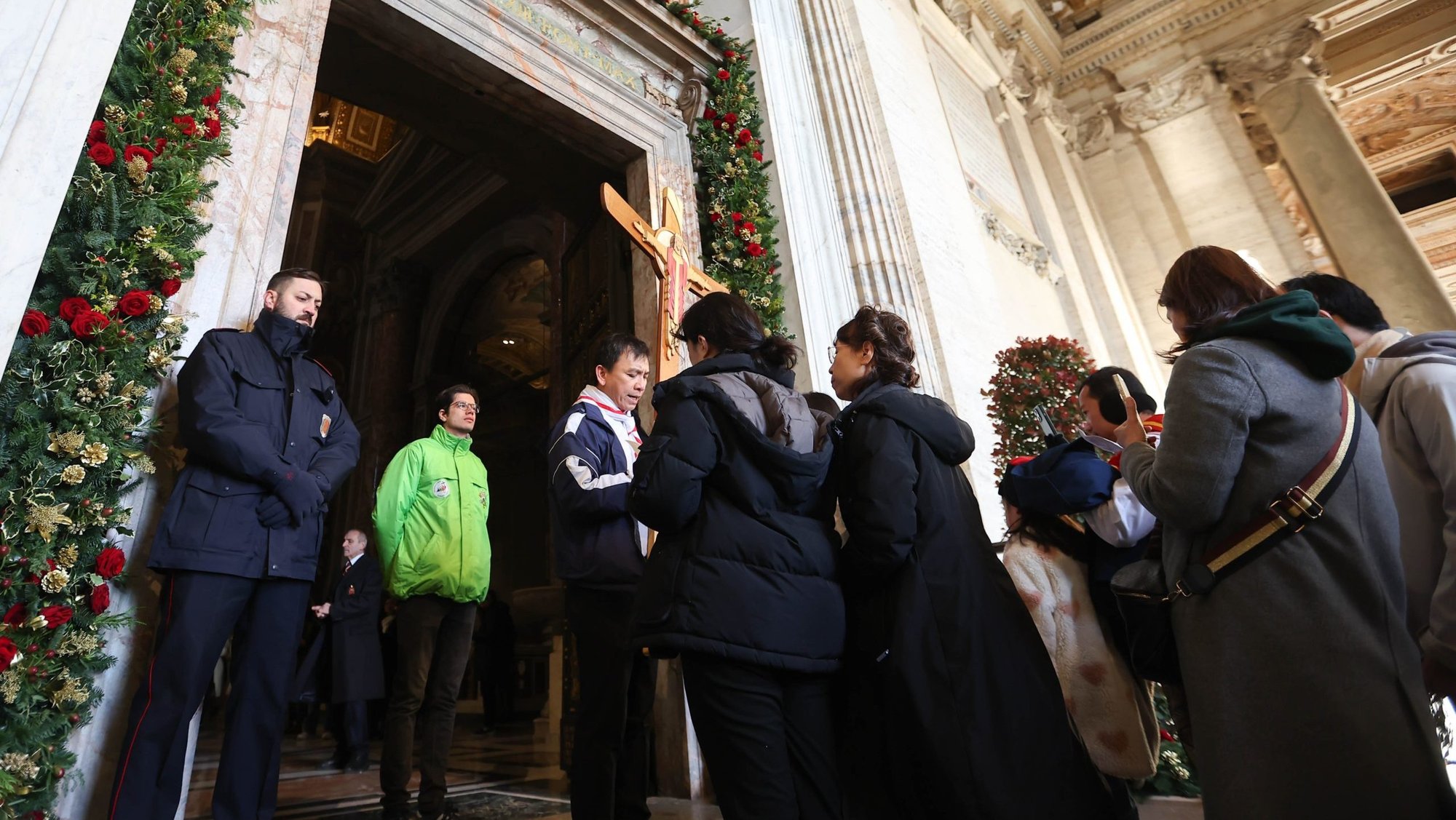 Pilgrims pray before the Holy Door of St. Peter’s Basilica on Christmas Day, Dec. 25, 2024, after it was opened by Pope Francis during Christmas Mass the night prior to mark the start of the Holy Year 2025. (CNS photo/Lola Gomez)