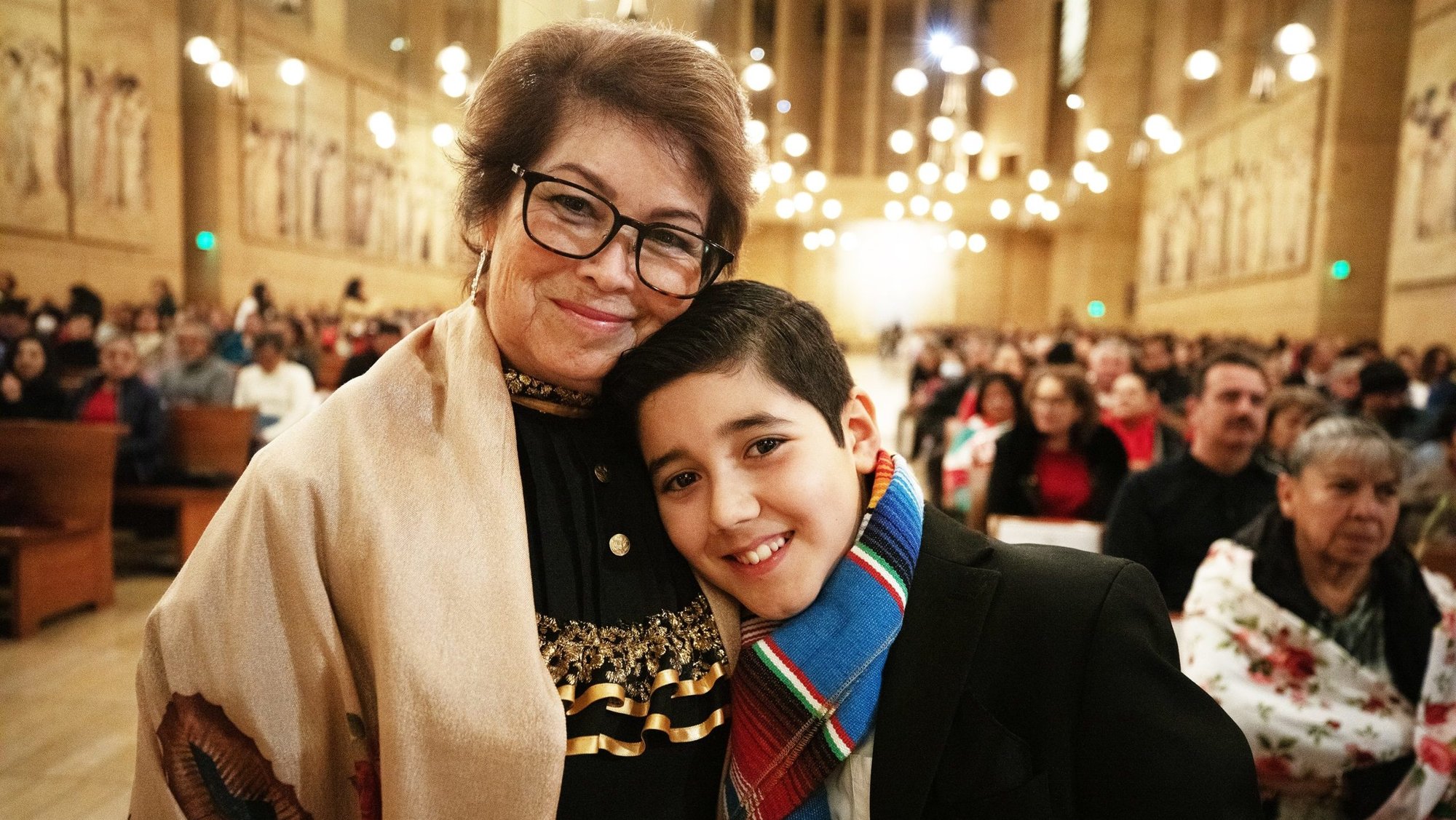 Rosa Gonzalez, left, smiles with her grandson, Sebastian, 12, after he upheld the family tradition of reciting the rosary at the Las Mañanitas vigil celebrating Our Lady of Guadalupe. (Victor Alemán)