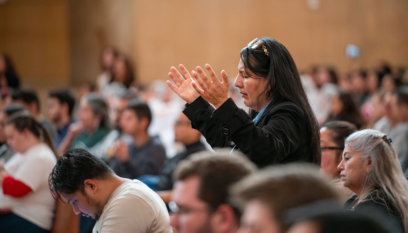 A woman raises her hands in prayer during the OneLife LA family festival Jan. 18. (Archdiocese of Los Angeles)