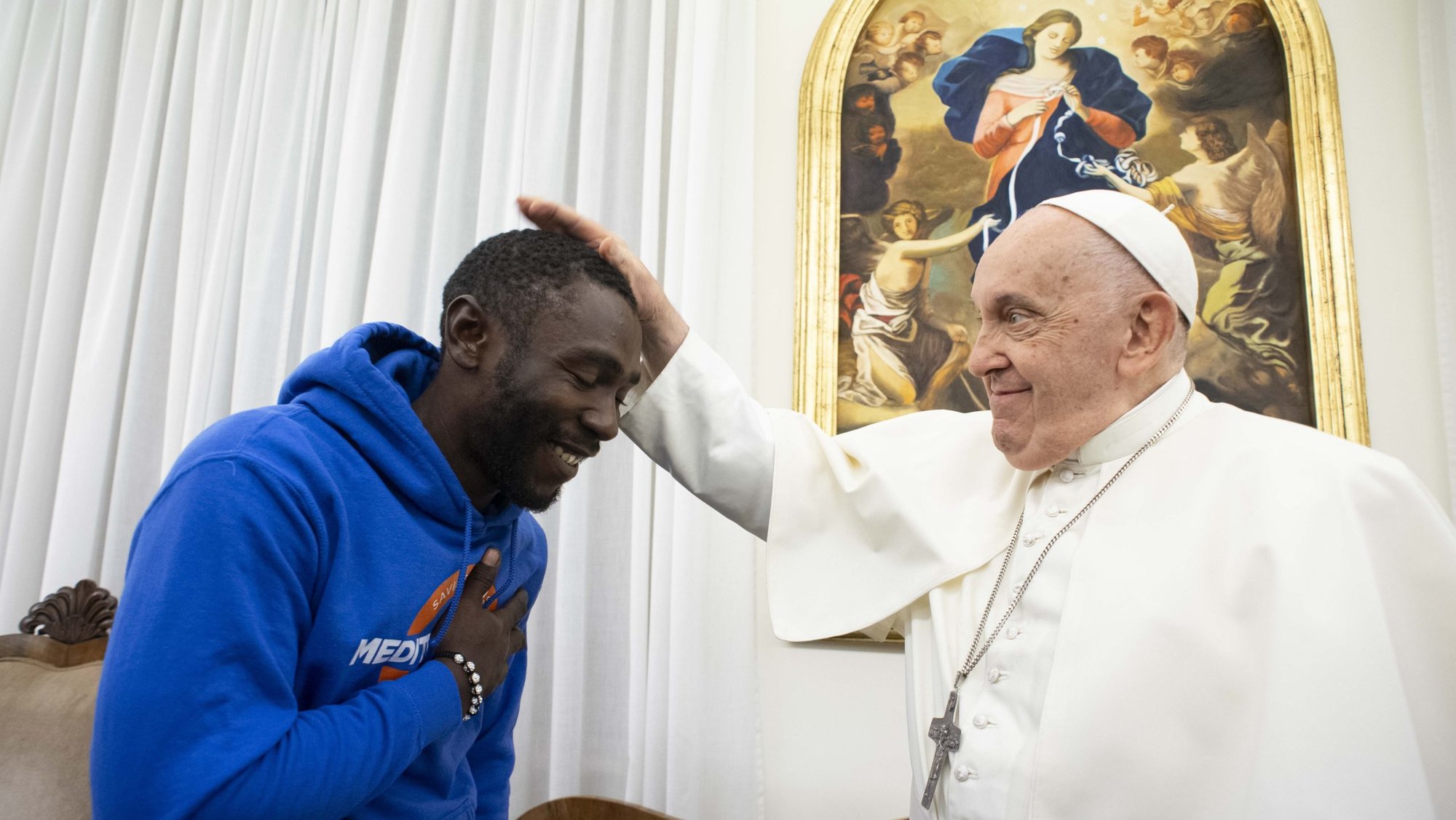 Pope Francis blesses Mbengue Nyimbilo Crepin, a migrant from Cameroon whose wife and daughter died in July crossing the North African desert, during a meeting in the Domus Sanctae Marthae at the Vatican Nov. 17, 2023. (CNS photo/Vatican Media)