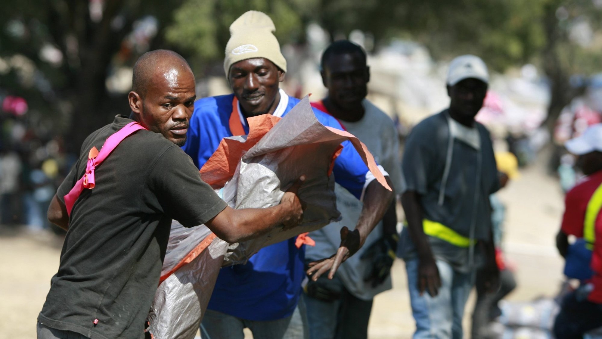 Workers distribute shelter kits assembled by Catholic Relief Services at a camp for survivors of the 2010 earthquake in Port-au-Prince, Haiti. The Catholic Relief Services Collection takes place in many dioceses March 18-19, 2023, to support the U.S. church's work overseas. (OSV News photo/Bob Roller)