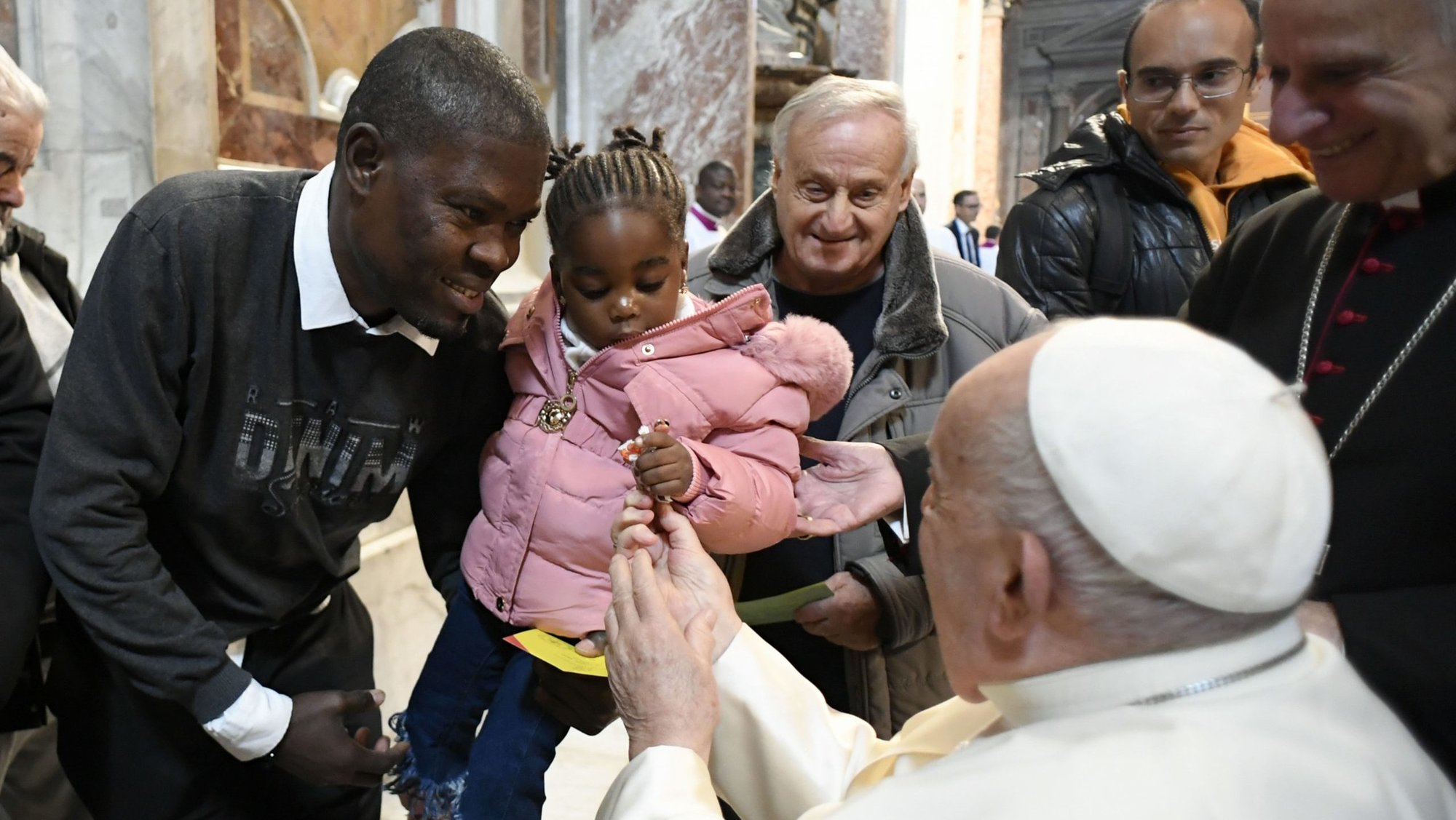 Pope Francis offers candy to a child after celebrating Mass for the World Day of the Poor in St. Peter's Basilica Nov. 17, 2024. (CNS photo/Vatican Media)