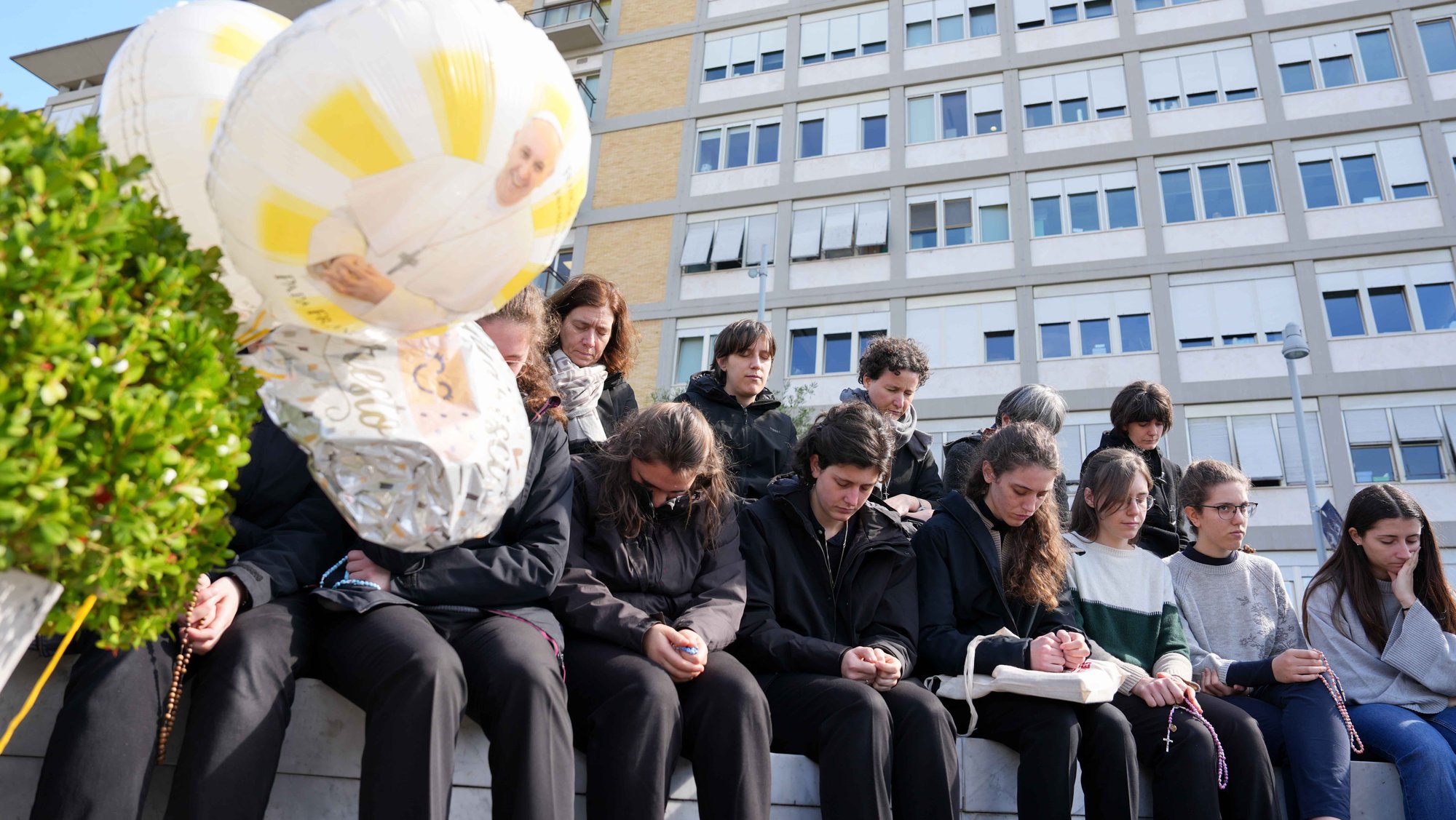 Young people and members of the House of Mary, groups associated with the Pontifical Academy of the Immaculate Conception, pray outside Rome’s Gemelli hospital March 2, 2025. Pope Francis is receiving treatment there for double pneumonia. (CNS photo/Lola Gomez)