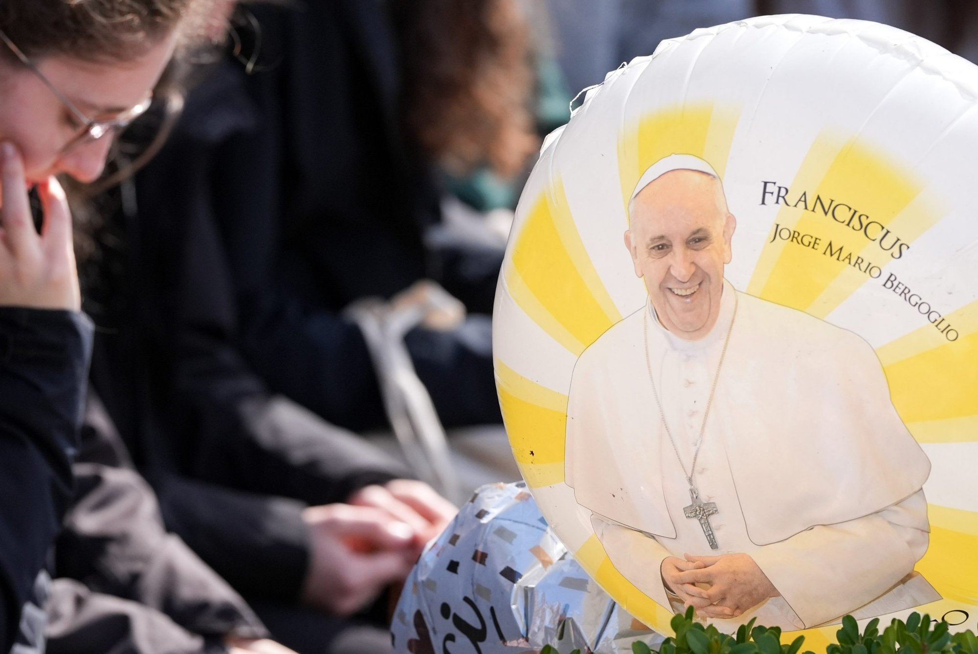 A balloon featuring an image of Pope Francis is seen as people pray outside Rome’s Gemelli hospital March 2, 2025. (CNS/Lola Gomez)
