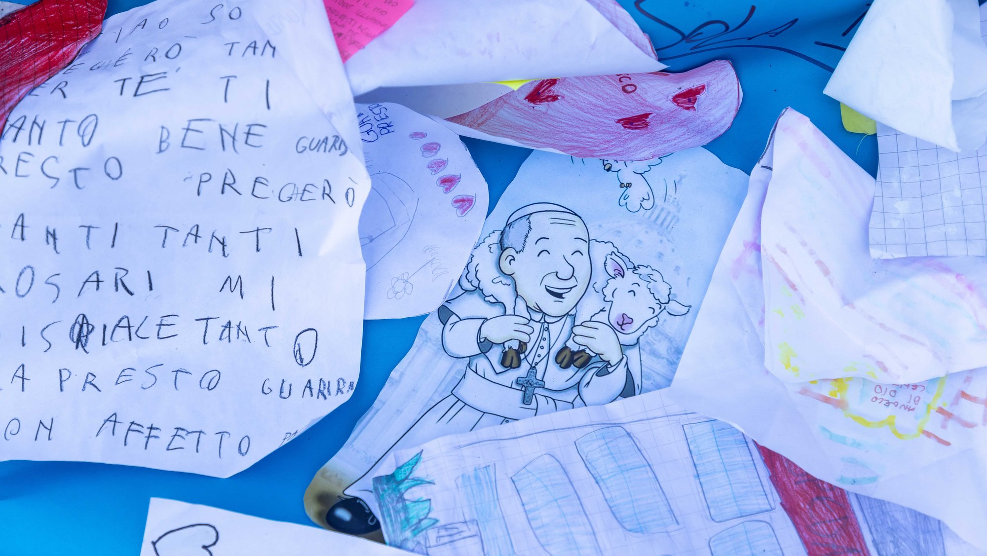 Drawings and messages are seen at the base of a statue of St. John Paul II outside of Rome's Gemelli hospital March 19, 2025. (CNS photo/Pablo Esparza)