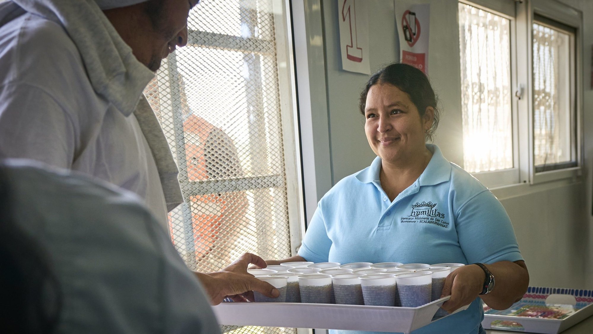 Ana Lopez offers a soft drink to migrants deported from the United States as they arrive at a church-run reception center at the international airport in San Pedro Sula, Honduras, on March 24, 2025. The deportees were welcomed back to Honduras by Scalabrinian Sister Idalina Bordignon, who directs the Center for Attention to Returned Migrants. (OSV News photo/Paul Jeffrey)
