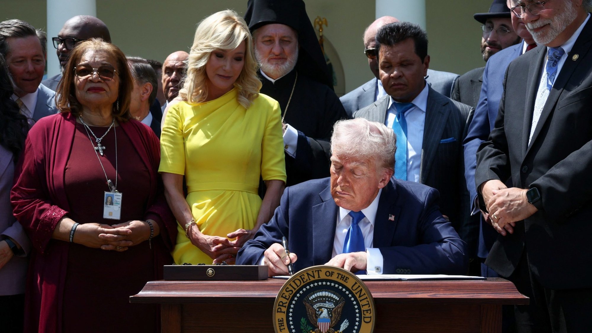 Surrounded by faith leaders, U.S. President Donald Trump signs an executive order on the "Establishment of the Religious Liberty Commission" during the National Day of Prayer in the Rose Garden at the White House in Washington May 1, 2025. Also pictured in yellow is Paula White, senior adviser to the White House Faith Office. (OSV News photo/Evelyn Hockstein, Reuters)