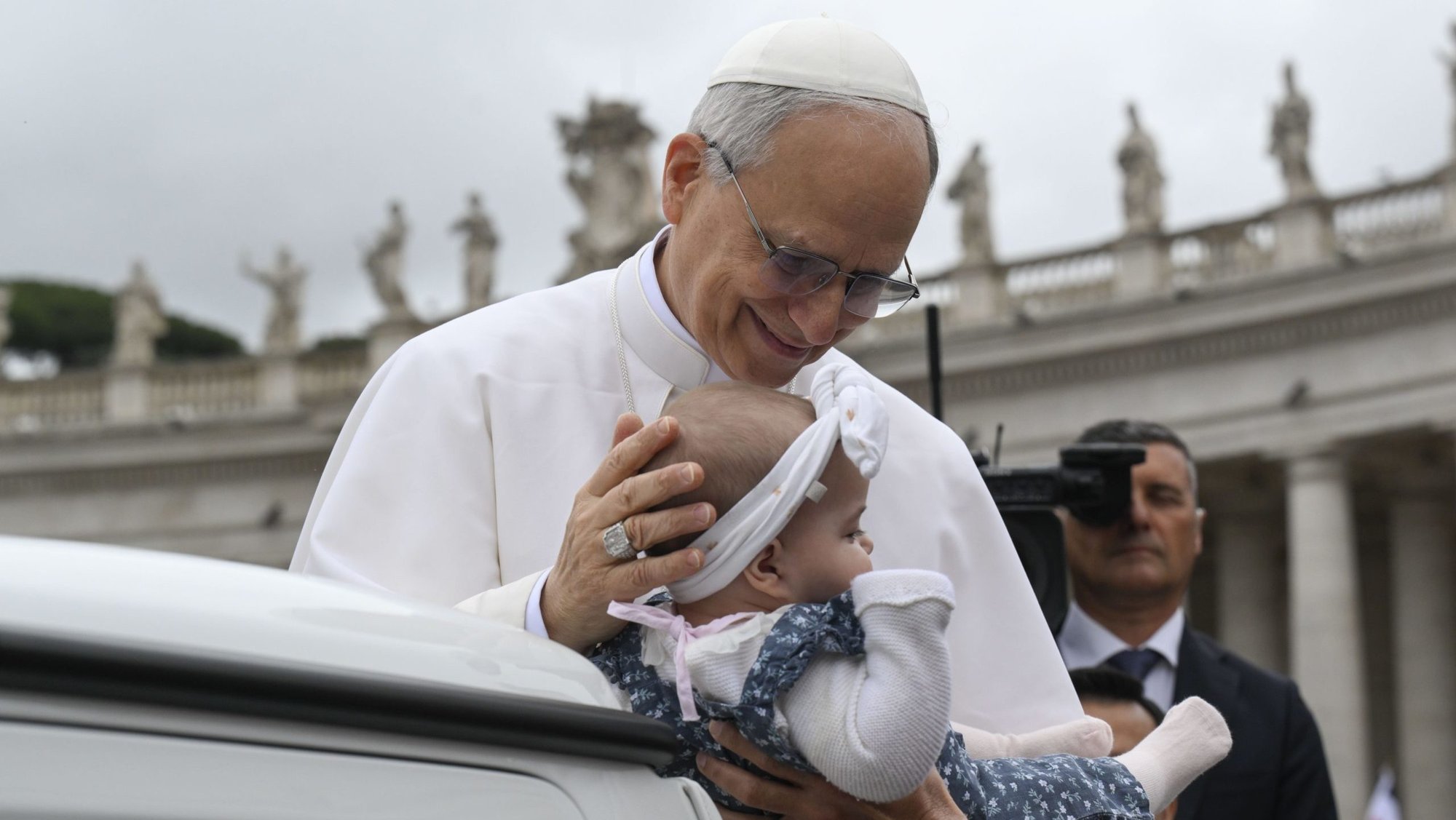 Pope Leo XIV blesses a baby as he rides in the popemobile around St. Peter's Square at the Vatican before his first weekly general audience May 21, 2025. (CNS photo/Vatican Media)