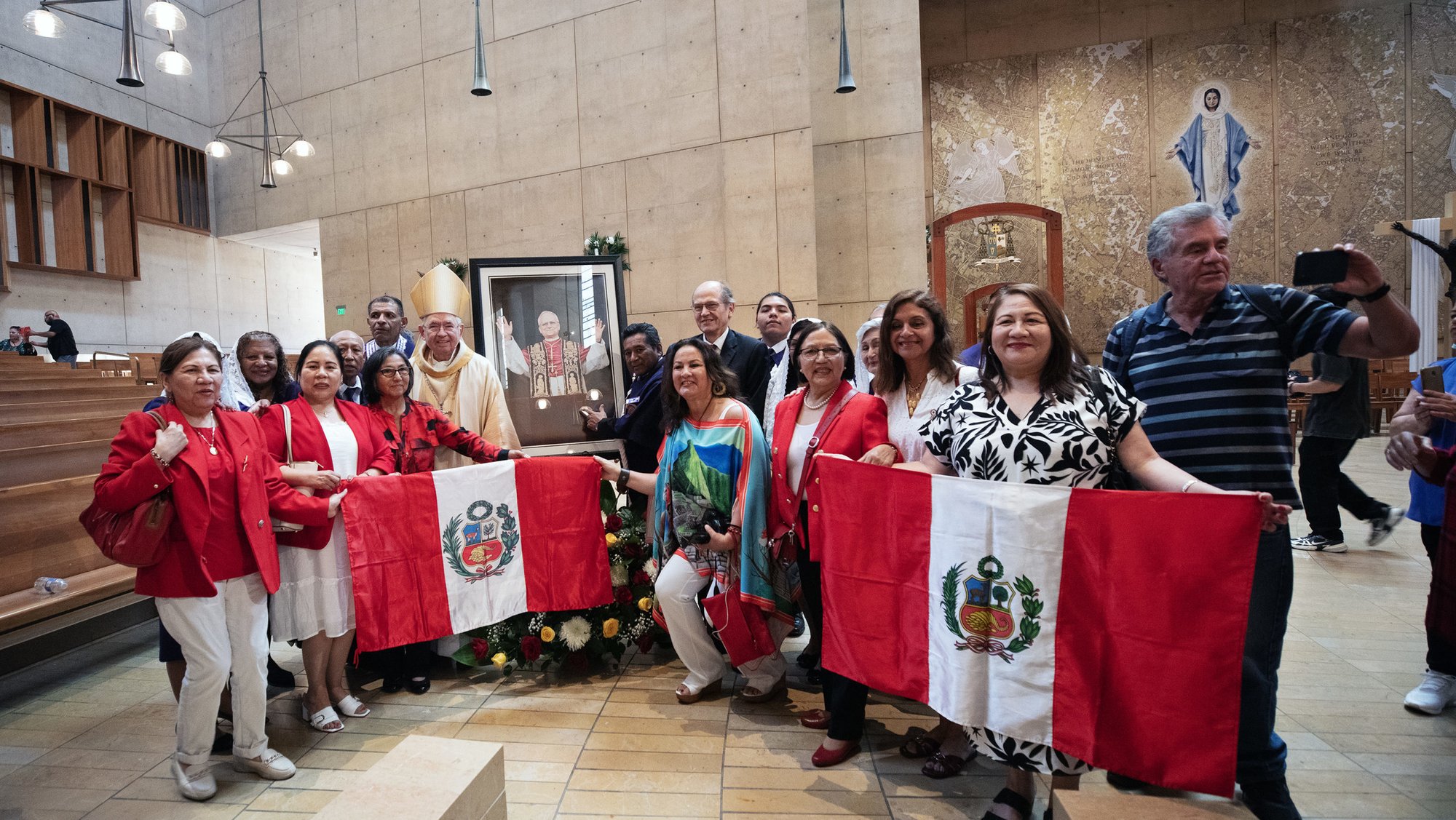 A group of Peruvian faithful pose with Archbishop José H. Gomez around a portrait of Pope Leo XIV following a special Mass celebrating the new pontiff on May 9. (Victor Alemán)
