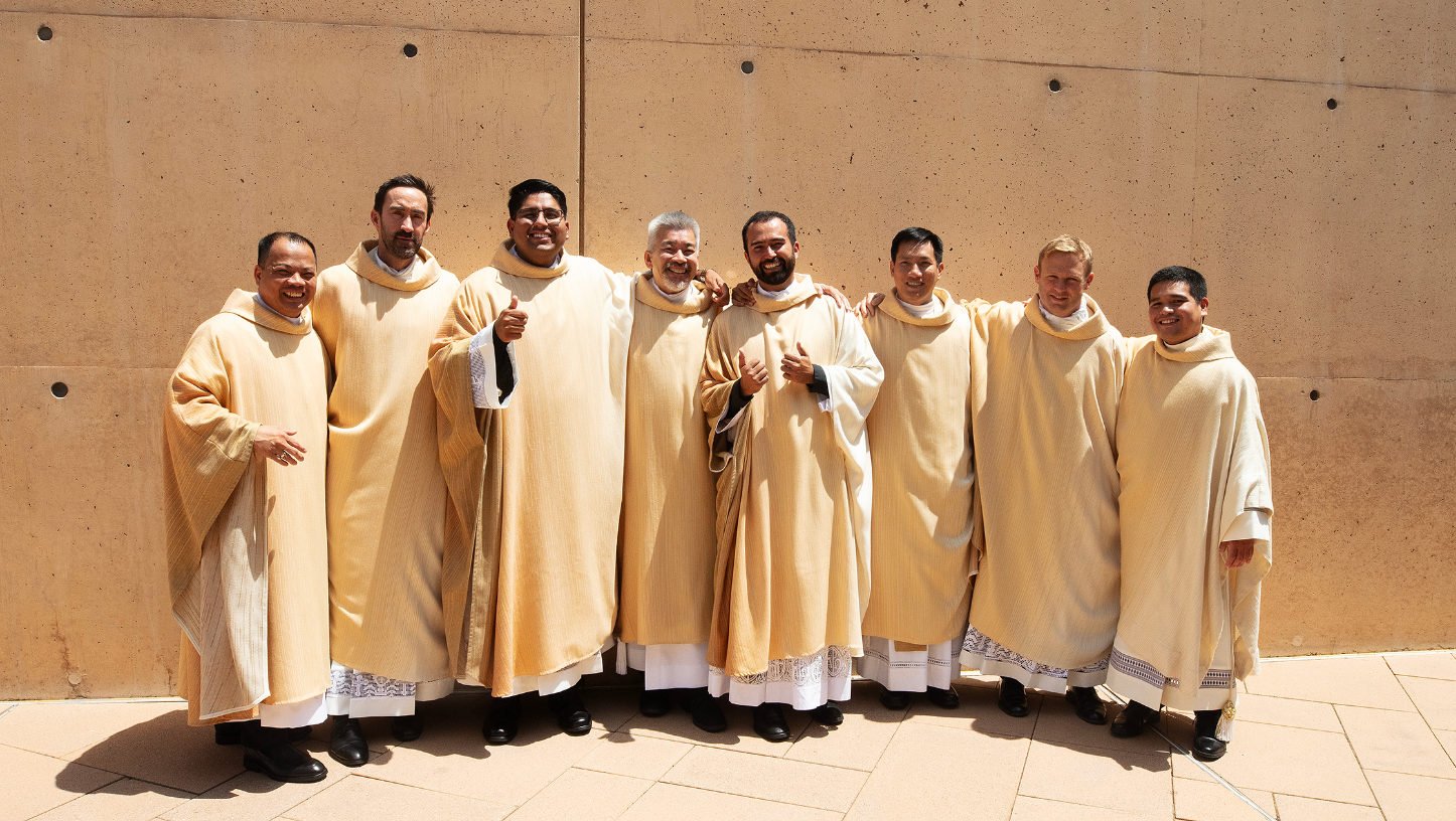 The newly ordained priests Father Allan Carodan, Father Michael Croghan, Father Jorge Moncada, Father Joseph Cruz, Father Christian Morquecho, Father Quoc Vo, Father Paul Collins, and Father Johndy Gonzales share a lighthearted moment following their ordination Mass on May 31. (Victor Alemán)