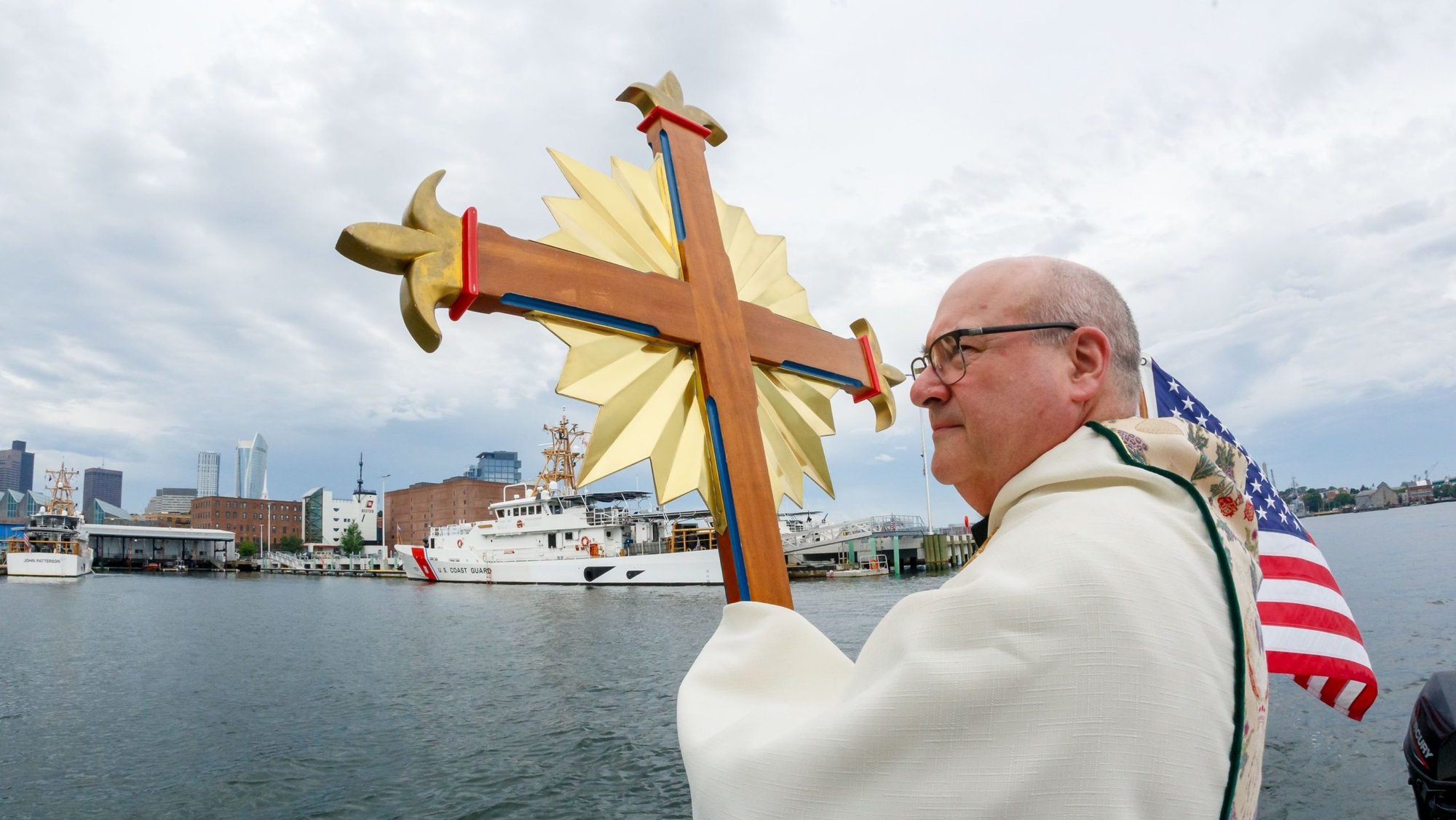Boston Archbishop Richard G. Henning holds the monstrance as he is brought by boat through Boston June 22, 2025, the second day of the archdiocese's "Into the Deep" Corpus Christi Eucharistic procession. During the two-day "procession by sea," the archbishop made stops to lead adoration in coastal towns to the north of Boston June 21 and in Boston Harbor June 22. (OSV News/Gregory L. Tracy, The Pilot)