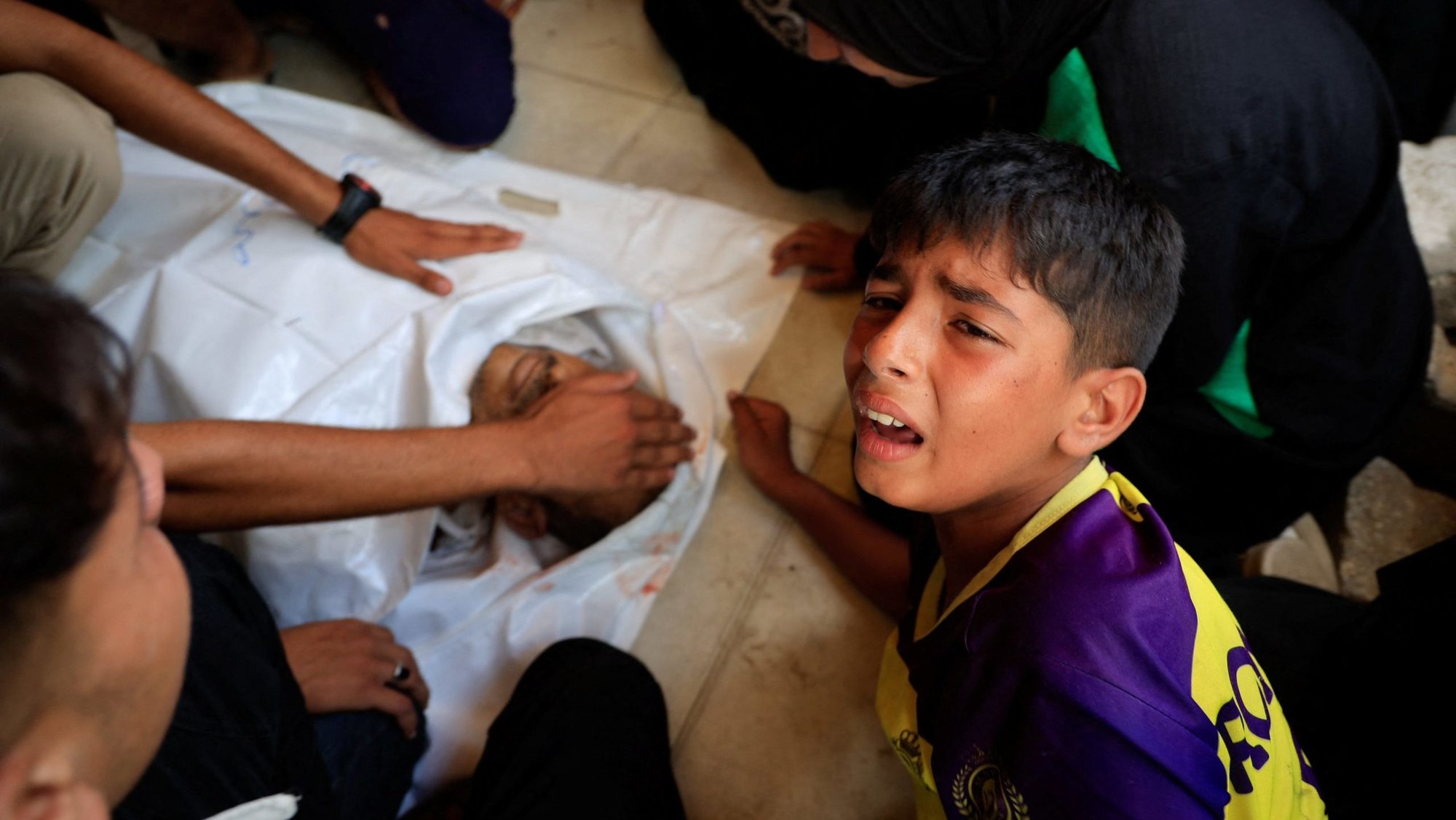 A Palestinian boy mourns next to the body of his father at Nasser Hospital in Khan Younis, southern Gaza Strip, July 14, 2025, during the funeral of Palestinians killed in during Israeli strikes on tents sheltering displaced people, according to medics. (OSV News photo/Hatem Khaled, Reuters)