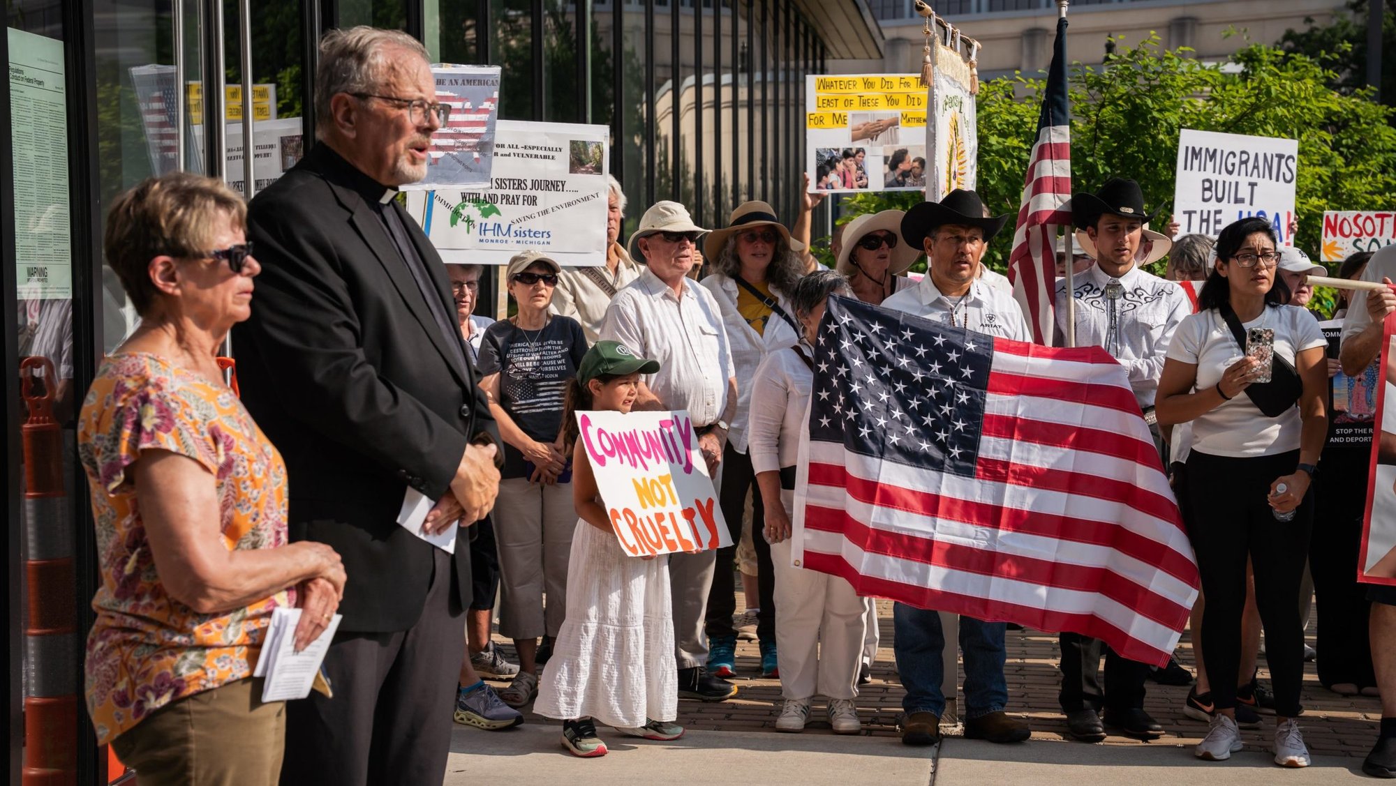 Judith Brooks, president of the Detroit-based immigrants' rights grassroots organization Strangers No Longer, and Father David Buersmeyer, the group's chaplain, address nearly 250 people of various faiths who took part in a solemn procession July 14, 2025, to the U.S. Immigration and Customs Enforcement's Detroit Field Office. (OSV News photo/Valaurian Waller, Detroit Catholic)