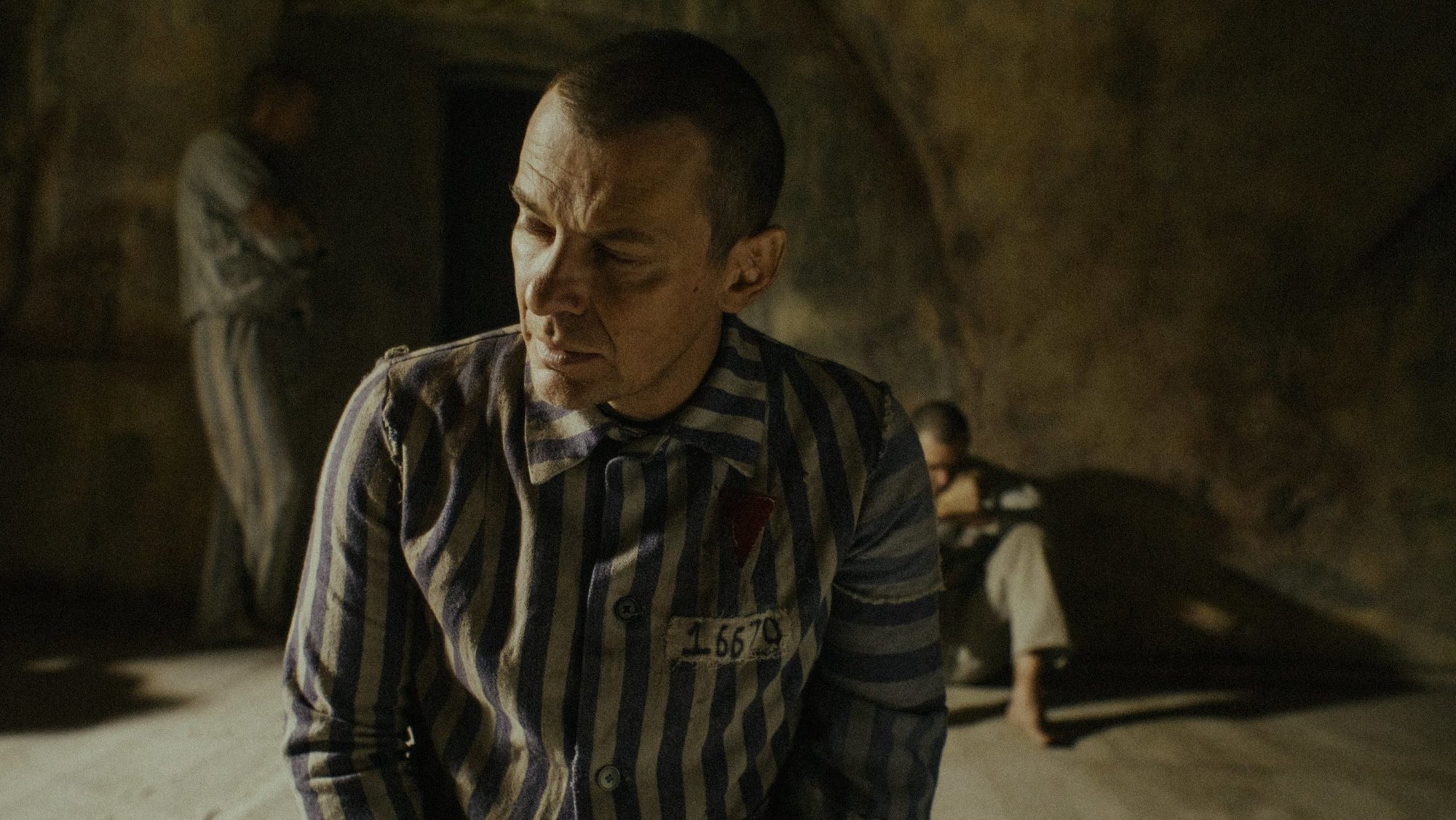 Polish actor Marcin Kwasny portrays Polish Conventual Franciscan Father Maximilian Kolbe in the death starvation cell at the Nazis' main Auschwitz concentration camp, where he died Aug. 14, 1941. The priest's last moments are the core story of a new movie about him titled "Triumph of the Heart" by American filmmaker Anthony D'Ambrosio, which premiered Aug. 13, 2025, in Poland and is set to arrive in U.S. theaters Sept. 12. Father Kolbe was canonized in 1982. (OSV News photo/courtesy Rafael Film)