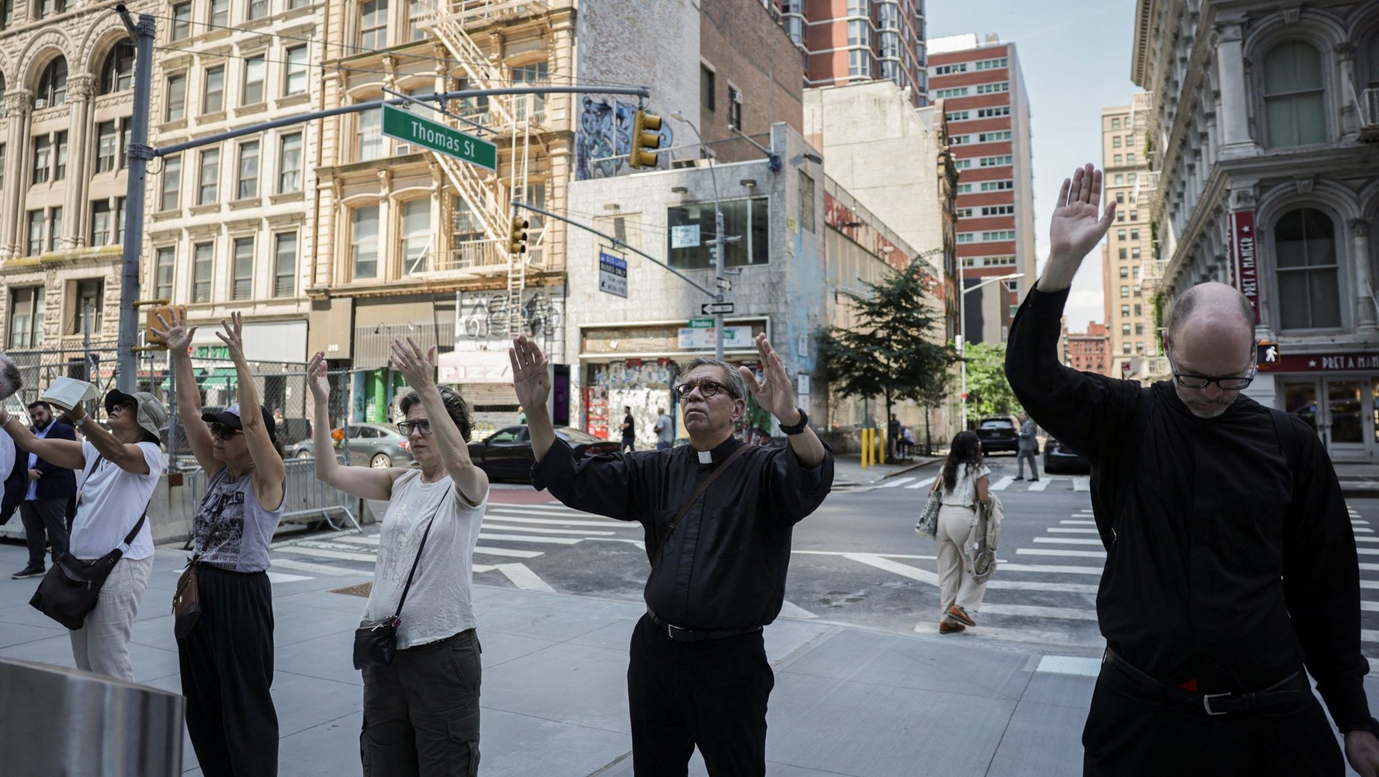 A clergyman and others pray during a silent vigil protesting U.S. Immigration and Customs Enforcement outside the U.S. immigration court in New York City, July 24, 2025. (OSV News photo/Jeenah Moon, Reuters)