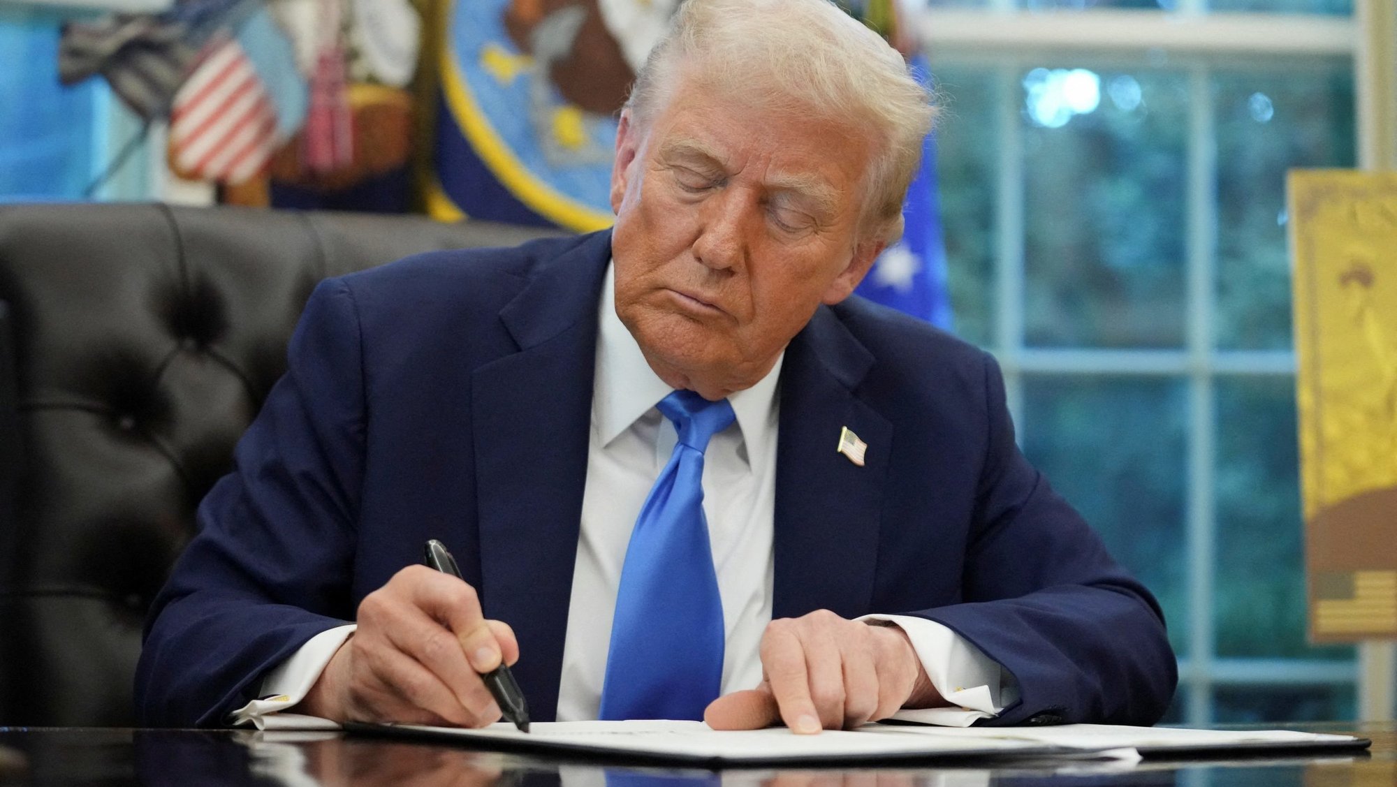 U.S. President Donald Trump signs an executive order in the Oval Office at the White House in Washington Sept. 19, 2025. Trump signed two executive orders, one to establish a visa program overseen by the secretary of commerce called the "Trump Gold Card" and one to introduce a $100,000 fee for H-1B visas. (OSV News photo/Ken Cedeno, Reuters)