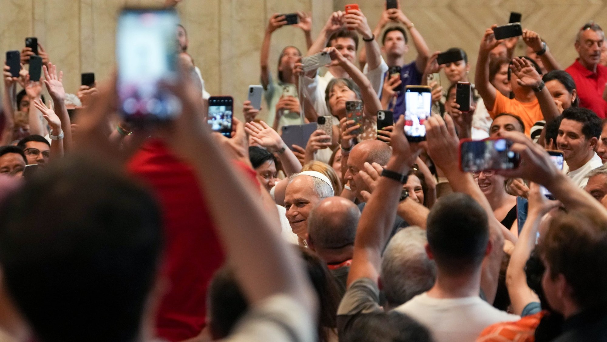 Pope Leo XIV, in choosing a theme for World Communications Day 2026, highlights the need to safeguard human voices and faces in the digital era, ensuring technology like artificial intelligence serves humanity rather than replacing it. In this file photo from June 14, 2025, Pope Leo greets people as they hold up cellphones to take photos and videos as he enters St. Peter’s Basilica for an audience with pilgrims in Rome for the Holy Year 2025. (CNS photo/Lola Gomez)