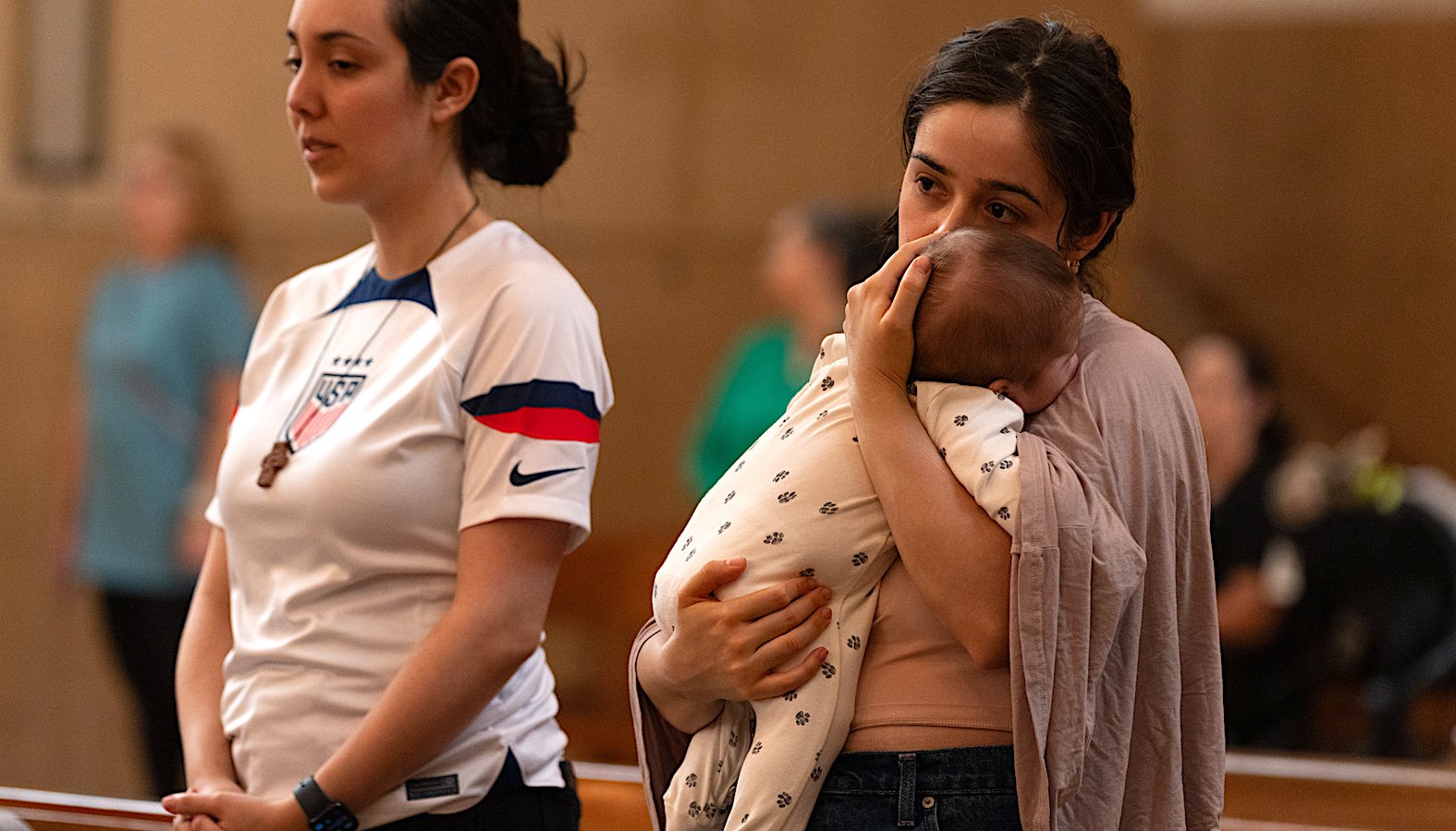 A mother holds her baby during the Mass in Recognition of All Immigrants at the Cathedral of Our Lady of the Angels on Sept. 21. (Evan Lirette)