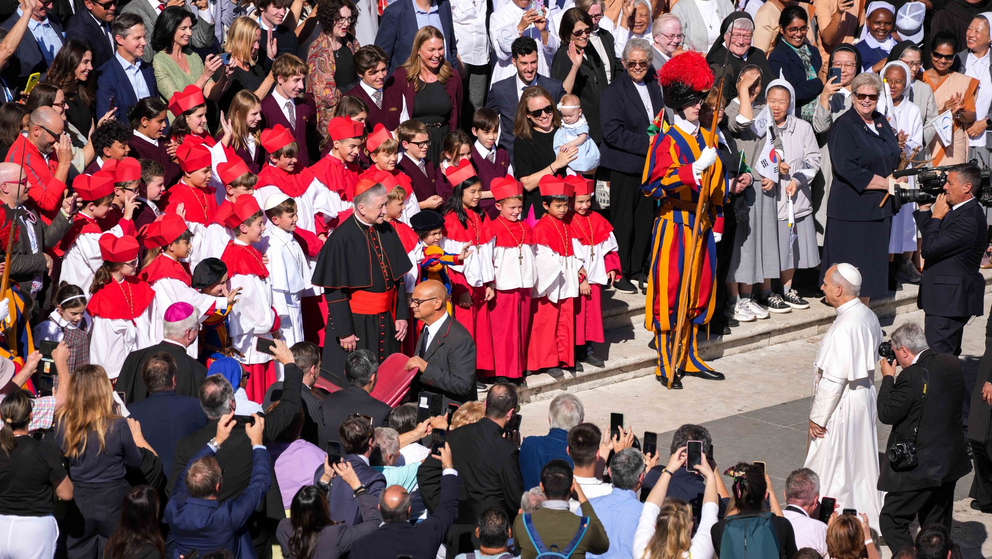 Pope Leo XIV approaches to greet Cardinal Blase J. Cupich of Chicago and students from Our Lady of Mount Carmel Academy in Chicago dressed as cardinals and a pope at the end of his weekly general audience in St. Peter’s Square at the Vatican Oct. 8, 2025. The students had captured worldwide attention when they held a mock conclave at their school May 6, electing their own “pope,” fourth grader Augie Wilk, who took the name “Pope Augustine,” just days before the election of Pope Leo, a fellow Chicagoan and Augustinian. (CNS photo/Lola Gomez)