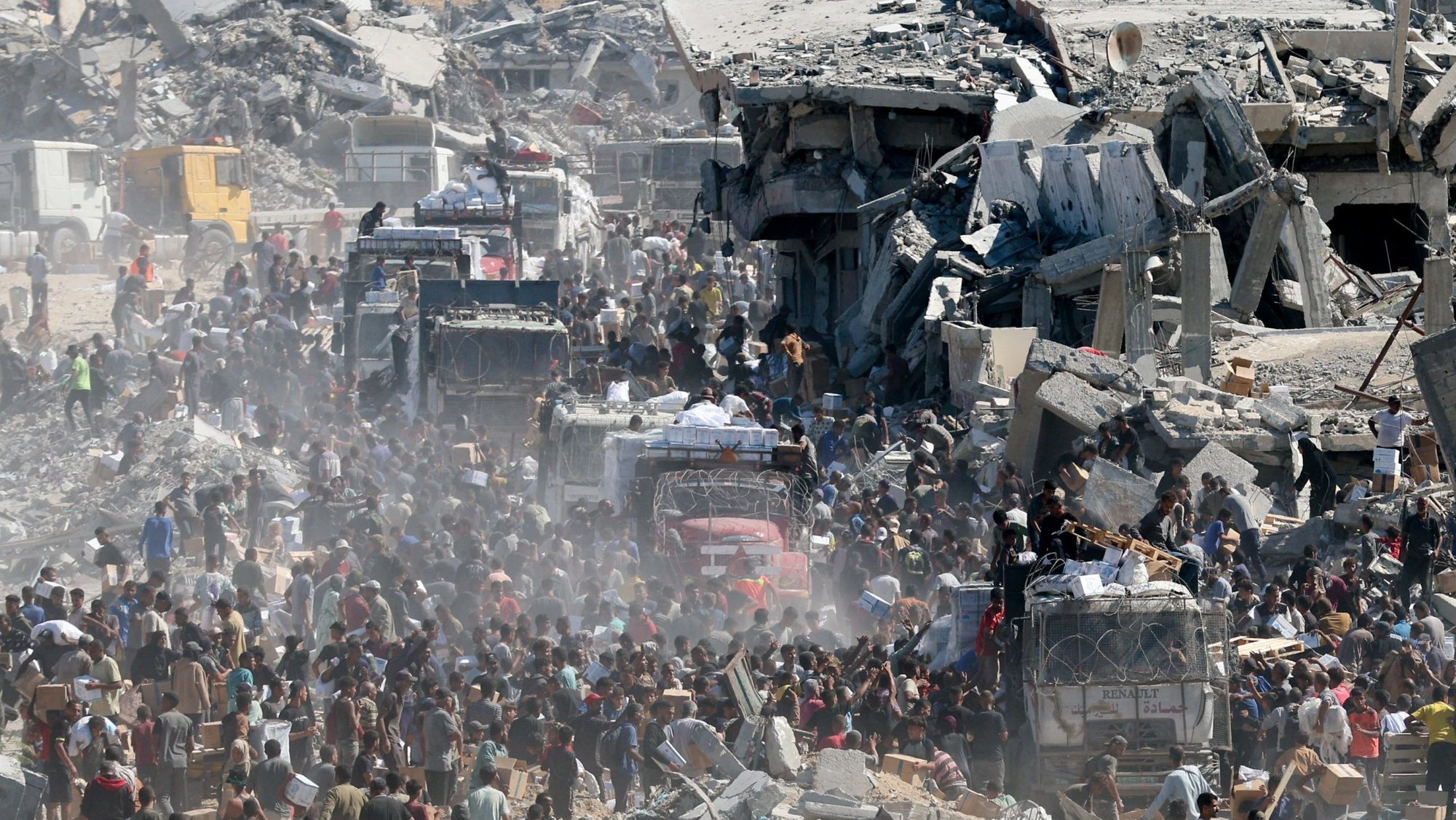 Palestinians collect aid supplies from trucks that entered the Gaza Strip, amid a ceasefire between Israel and Hamas in Gaza City, Oct. 12, 2025. (OSV News photo/Ramadan Abed, Reuters)