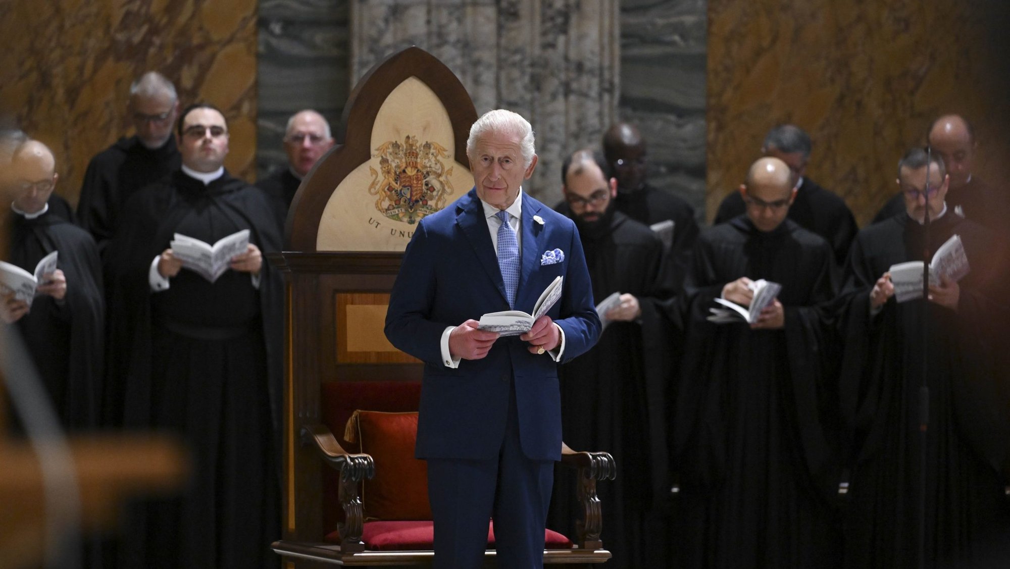 Britain's King Charles III stands in front of a chair made to mark his being honored as a "royal confrater" of the Benedictine monks at the abbey at Rome's Basilica of St. Paul Outside the Walls during an ecumenical prayer service Oct. 23, 2025. (CNS photo/Vatican Media)