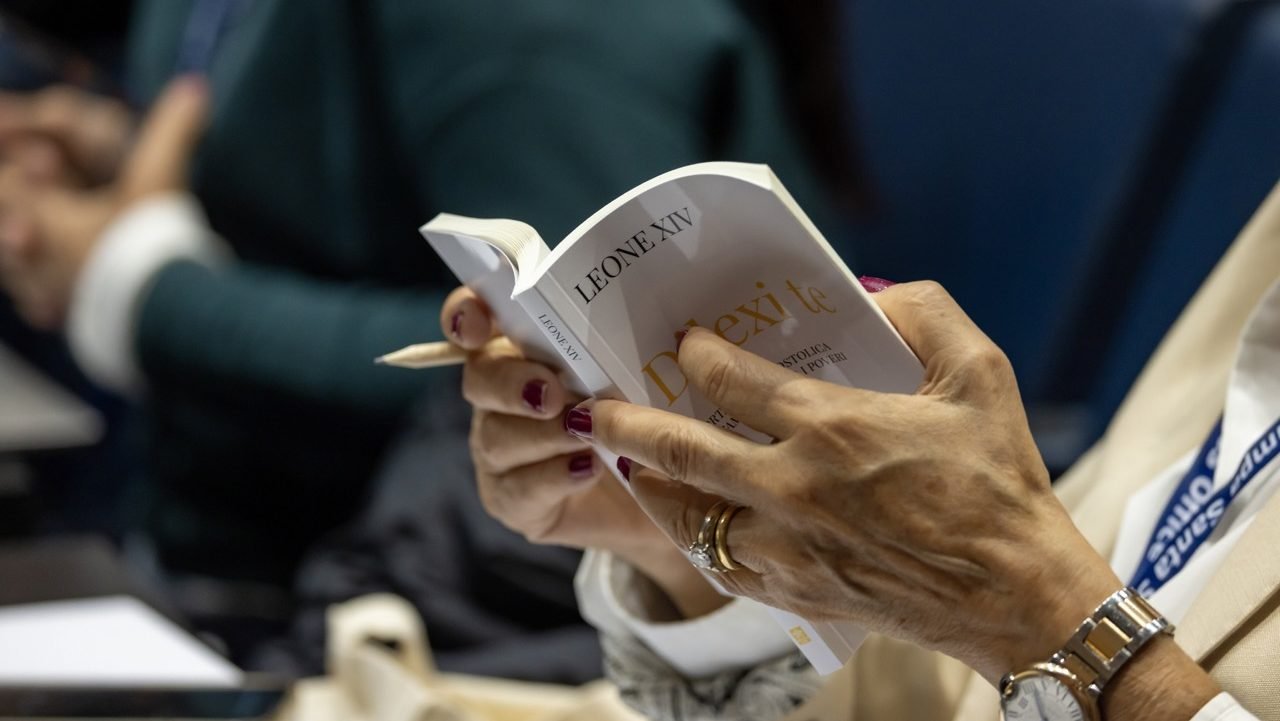 A journalist looks through the Italian translation of "Dilexi Te" ("I Have Loved You"), Pope Leo XIV's apostolic exhortation, during a news conference at the Vatican to present the document Oct. 9, 2025. (CNS photo/Pablo Esparza)