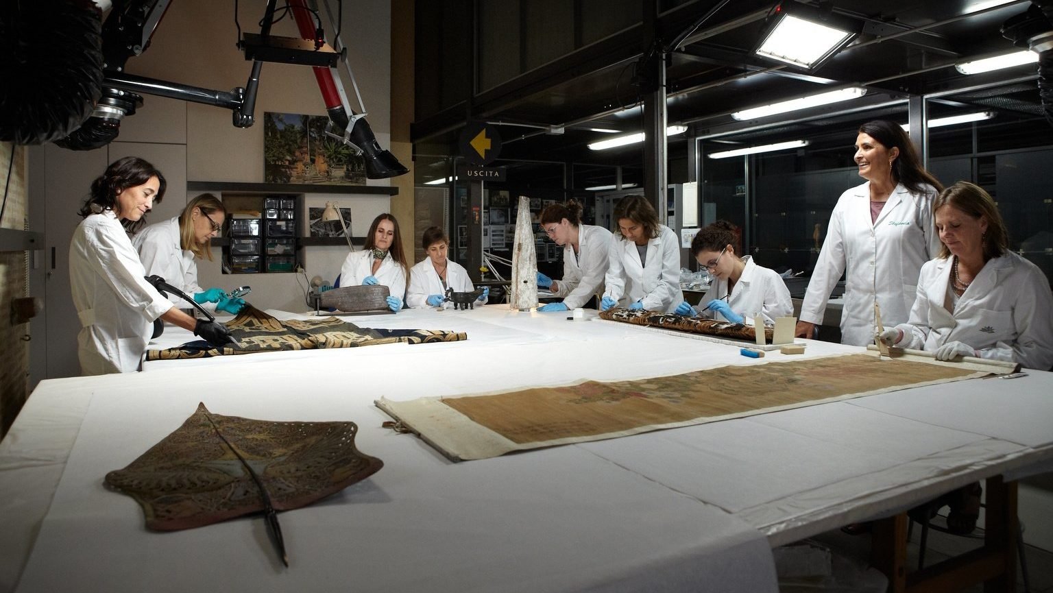 Expert restorers work in the conservation laboratory for ethnological materials at the Vatican Museums in this file photo from 2013. Many of the 100,000 artifacts sent to the Vatican via missionaries over the centuries are made of delicate materials such as ostrich plumes, leather and glass beads. (CNS photo/courtesy Vatican Museums)