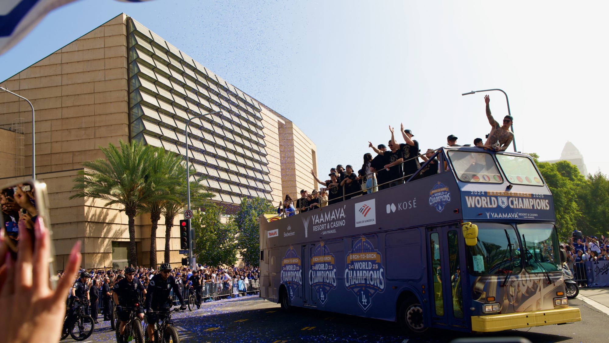Dodgers players and their families wave to the crowd as the Nov. 3 victory parade celebrating the team's World Series championship passes in front of the Cathedral of Our Lady of the Angels. (Reese Cuevas)