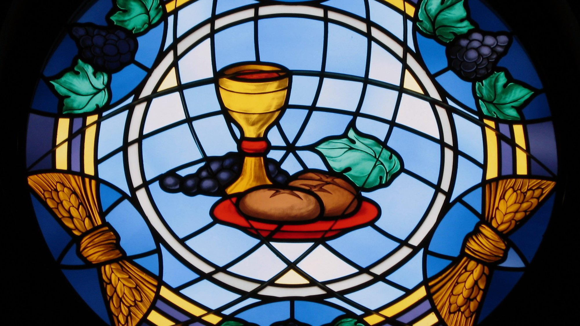 Eucharistic stained-glass window depicting bread and wine surrounded by a frame depicting grapes and ears of grain, in St. Michael the Archangel Church, Findlay, Ohio. (Wikimedia Commons)