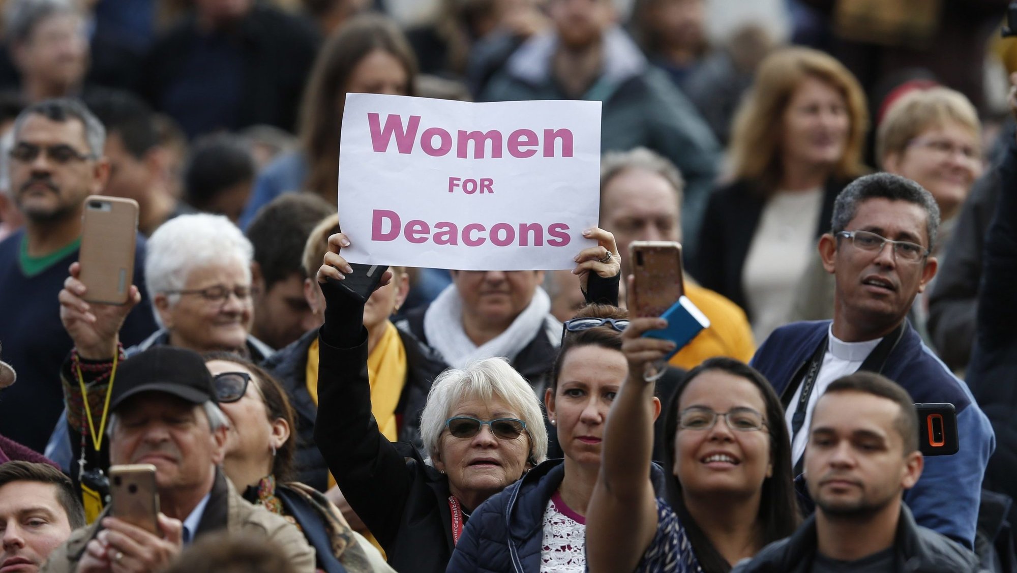 A woman holds a sign in support of women deacons as Pope Francis leads his general audience in St. Peter's Square at the Vatican Nov. 6, 2019. (CNS/Paul Haring)