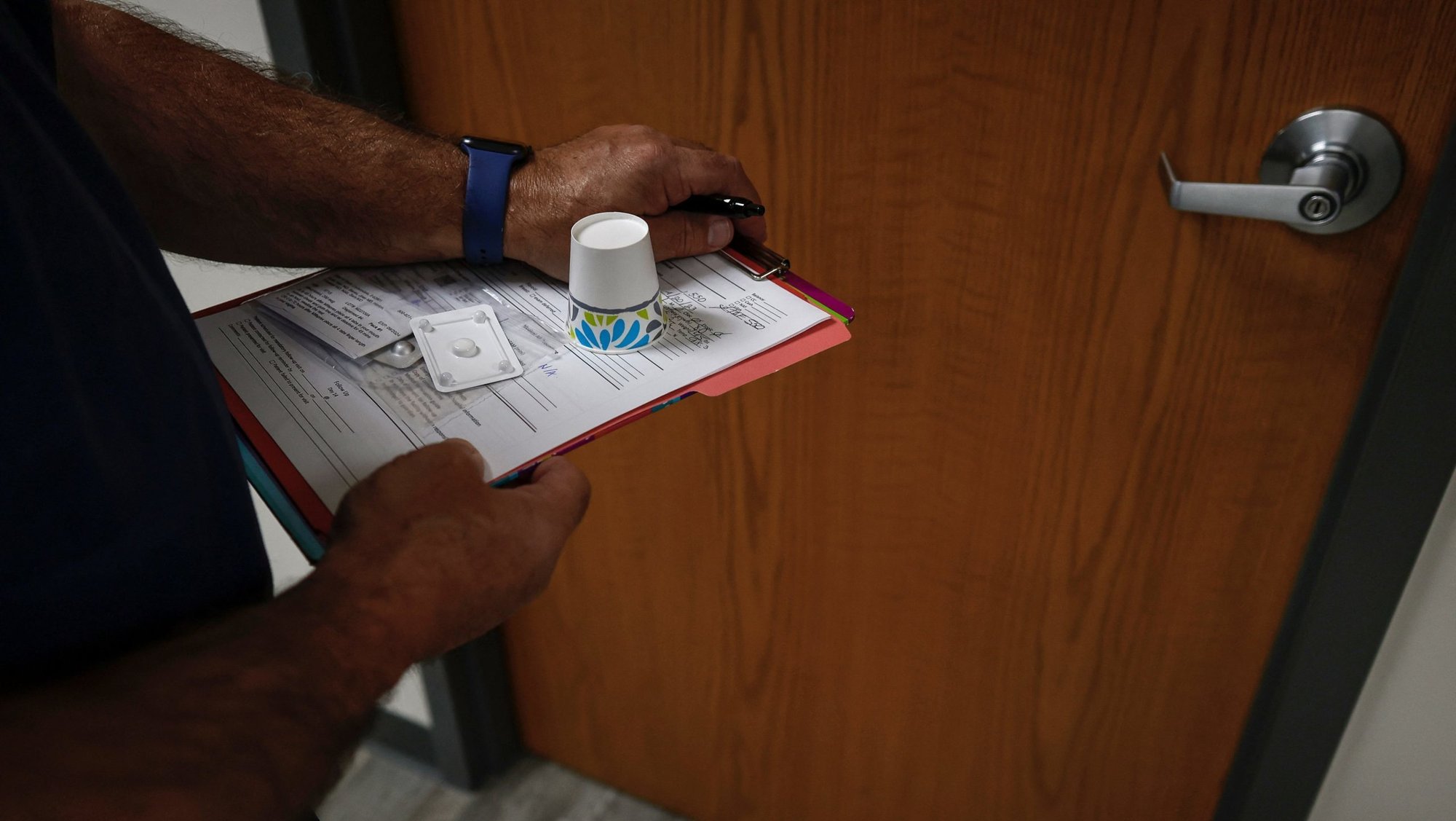 A doctor carries mifepristone, the first of two drugs used either in a medication-based abortion or in some miscarriage care protocols, to a patient waiting in an exam room at Alamo Women's Clinic in Carbondale, Ill., April 20, 2023. (OSV News photo/Evelyn Hockstein, Reuters)