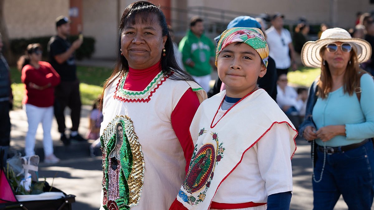 Attendees wearing clothing featuring Our Lady of Guadalupe walk during the 94th annual procession and Mass on Dec. 7. (Alfonso Romero)