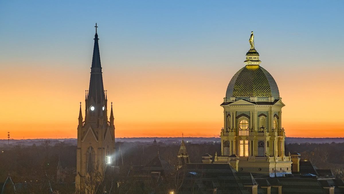 The sun sets over the main building and Basilica of the Sacred Heart steeple on the campus of the University of Notre Dame in South Bend, Ind., Nov. 23, 2025. The university is developing a faith-based approach to AI ethics through its DELTA Network, which just got a $50 million grant to boost those efforts. (OSV News photo/Matt Cashore, courtesy University of Notre Dame)