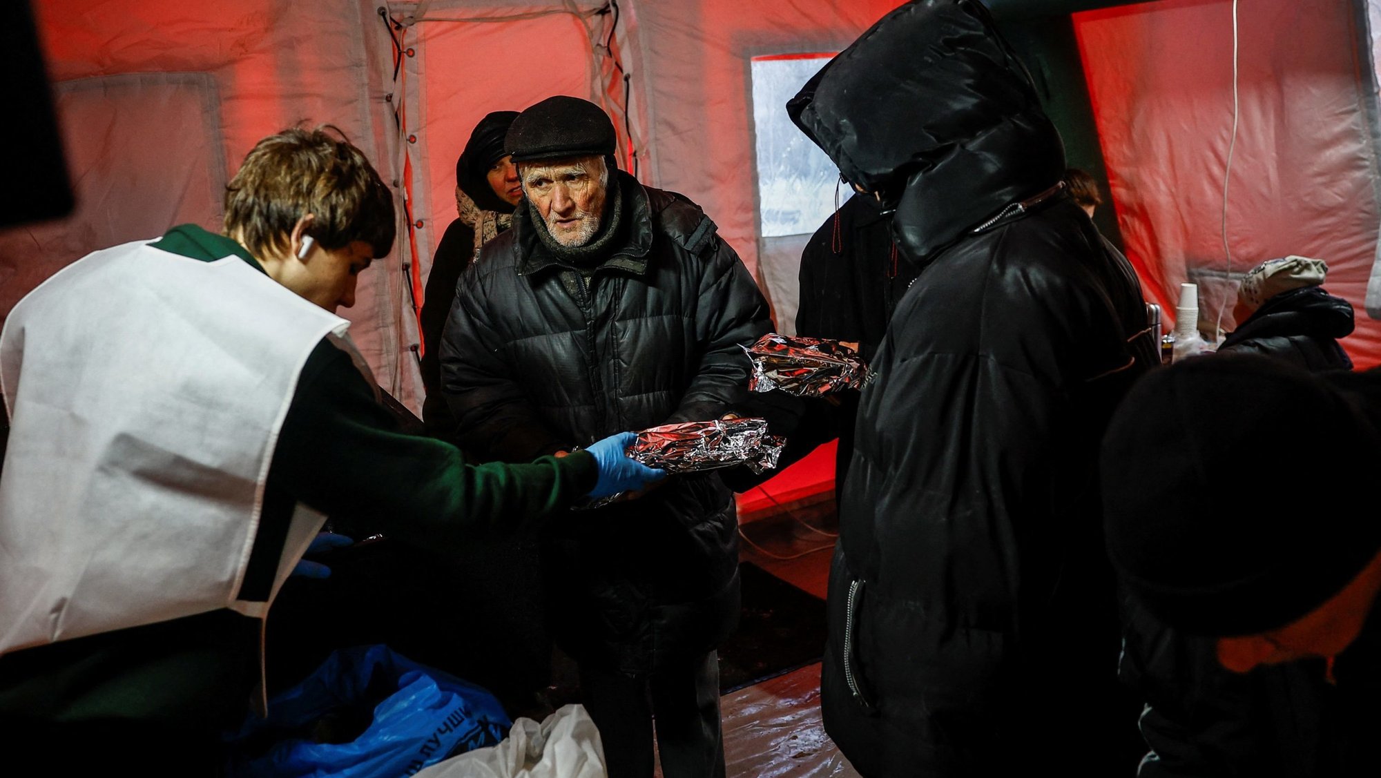 Residents receive hot meals inside a tent at a government-run humanitarian aid point in Kyiv, Ukraine, Jan. 23, 2026, as other locals warm up, charge their devices there, during a power blackout after critical civil infrastructure was hit by overnight Russian missile and drone strikes, amid Russia's full-scale invasion of Ukraine. (OSV News/Alina Smutko, Reuters)