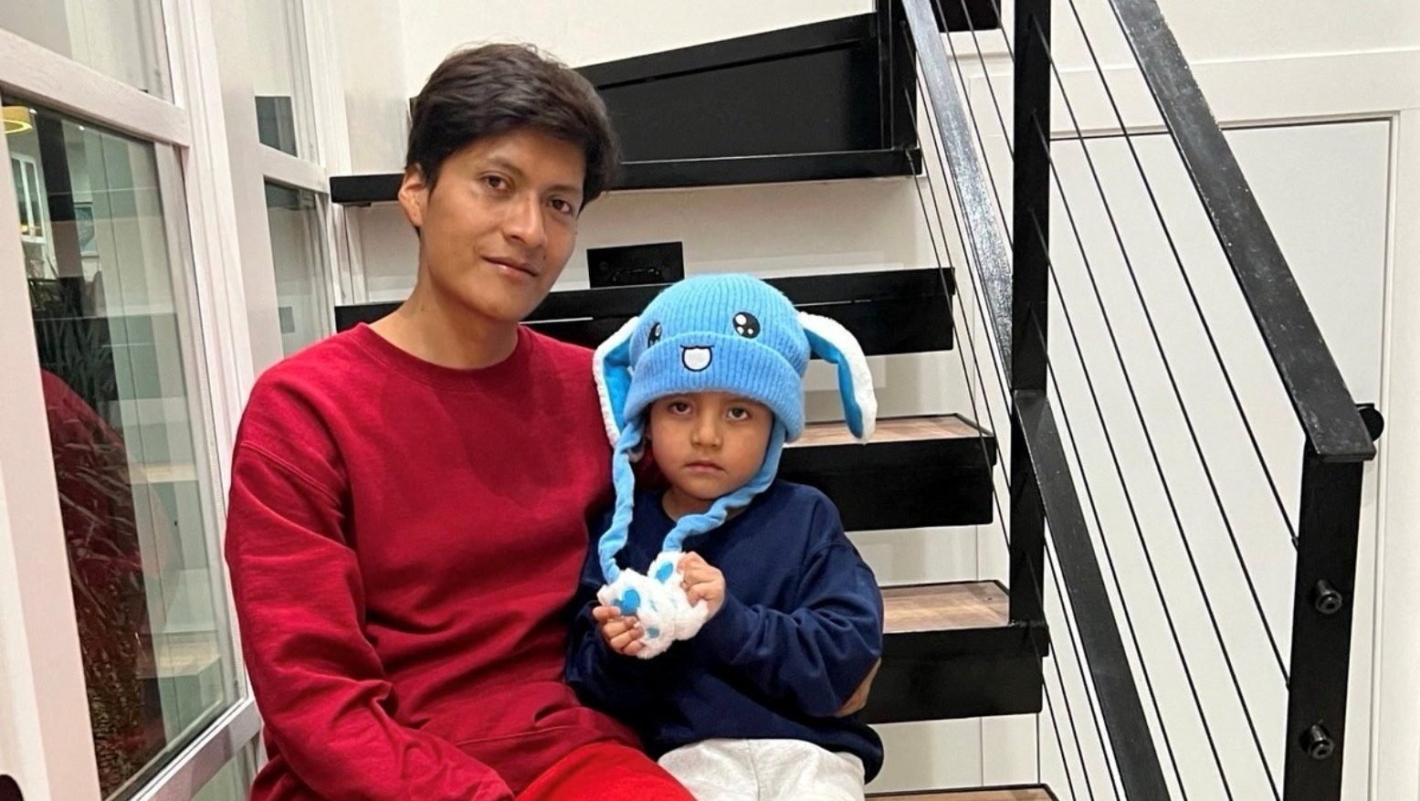 Liam Conejo Ramos, right, and his father Adrian Alexander Conejo Arias, who were detained by immigration officers in Minnesota and then taken to a detention center in Texas, sit on the stairs back at their home after a judge ordered their release, in Columbia Heights, Minn., in this picture obtained from social media Feb. 1, 2026. (OSV News photo/Joaquin Castro via BlueSky, via Reuters)