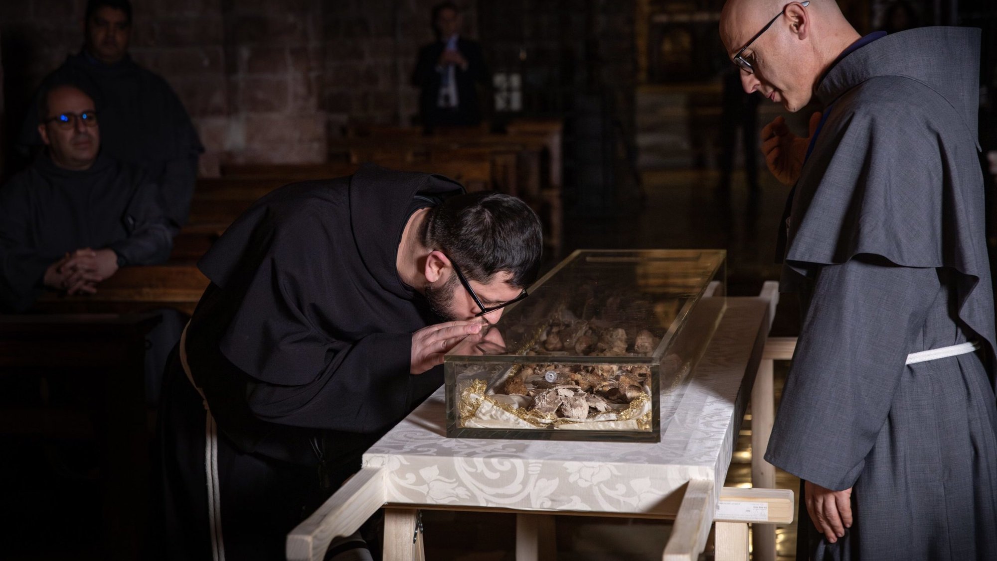 A monk from the local Franciscan community venerates the relics of St. Francis, which were exhumed from their shrine in the Basilica of St. Francis in Assisi, Italy, the morning of Feb. 21, 2026. The remains were exhumed in the presence of the friars and placed on a specially prepared table in the crypt, before being displayed for public veneration, which began Feb. 22 and runs through March 22. (OSV News photo/courtesy Sala Stampa Sacro Convento Assisi)