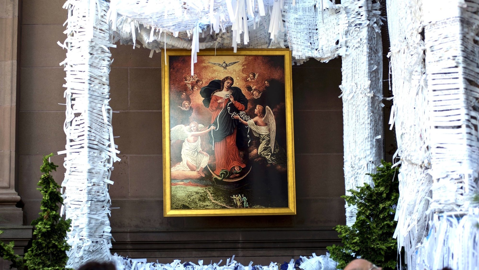 A painting of Mary Undoer of Knots hangs within the Knotted Grotto at the Cathedral Basilica of SS. Peter and Paul in Philadelphia during the World Meeting of Families. The project invites visitors to write their prayer intentions on the white strips and then tie them to the structure.(CNS/Carley Mossbrook)