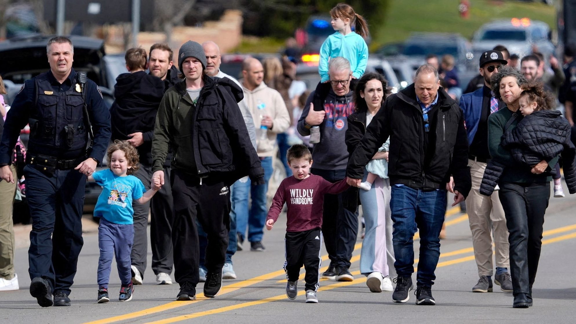 Parents are escorted by police down a road back to their cars after being reunited with their children after a suspect crashed his truck into the hallway of Temple Israel synagogue in West Bloomfield, Mich., March 12, 2026. An attacker armed with a rifle was fatally shot after ramming his vehicle into one of the nation's largest Reform synagogues in what federal investigators said was an act of violence targeting the Jewish community. (OSV News photo/Eric Seals, USA Today Network via Reuters)